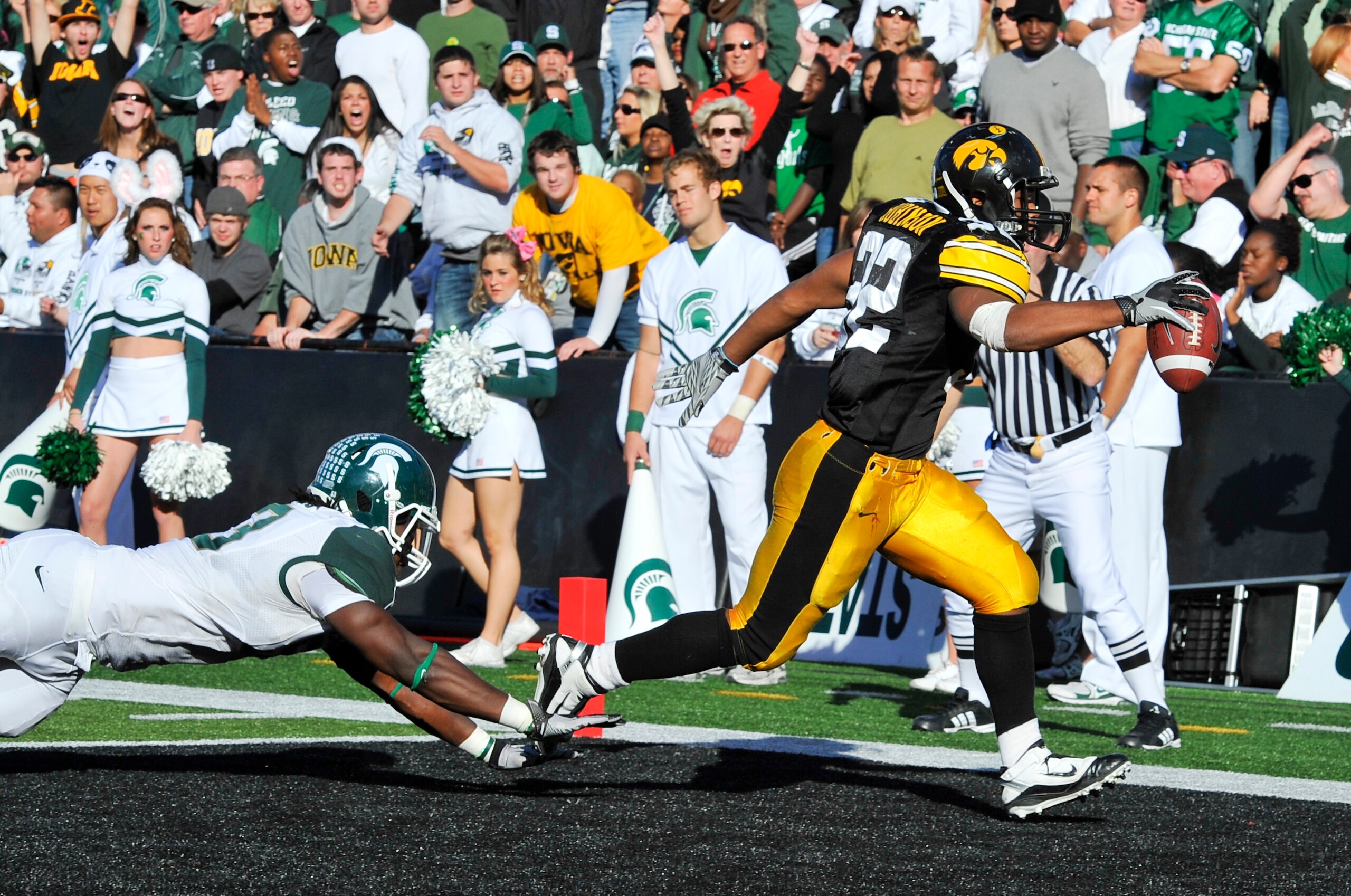 IOWA CITY, IA - OCTOBER 30: Running back Adam Robinson #32 of the University of Iowa Hawkeyes runs the ball into the end zone for a touchdown as line backer Greg Jones #53 of the Michigan State Spartans defends during the first half of play at Kinnick Sta IOWA CITY, IA - OCTOBER 30: Running back Adam Robinson #32 of the University of Iowa Hawkeyes runs the ball into the end zone for a touchdown as line backer Greg Jones #53 of the Michigan State Spartans defends during the first half of play at Kinnick Sta