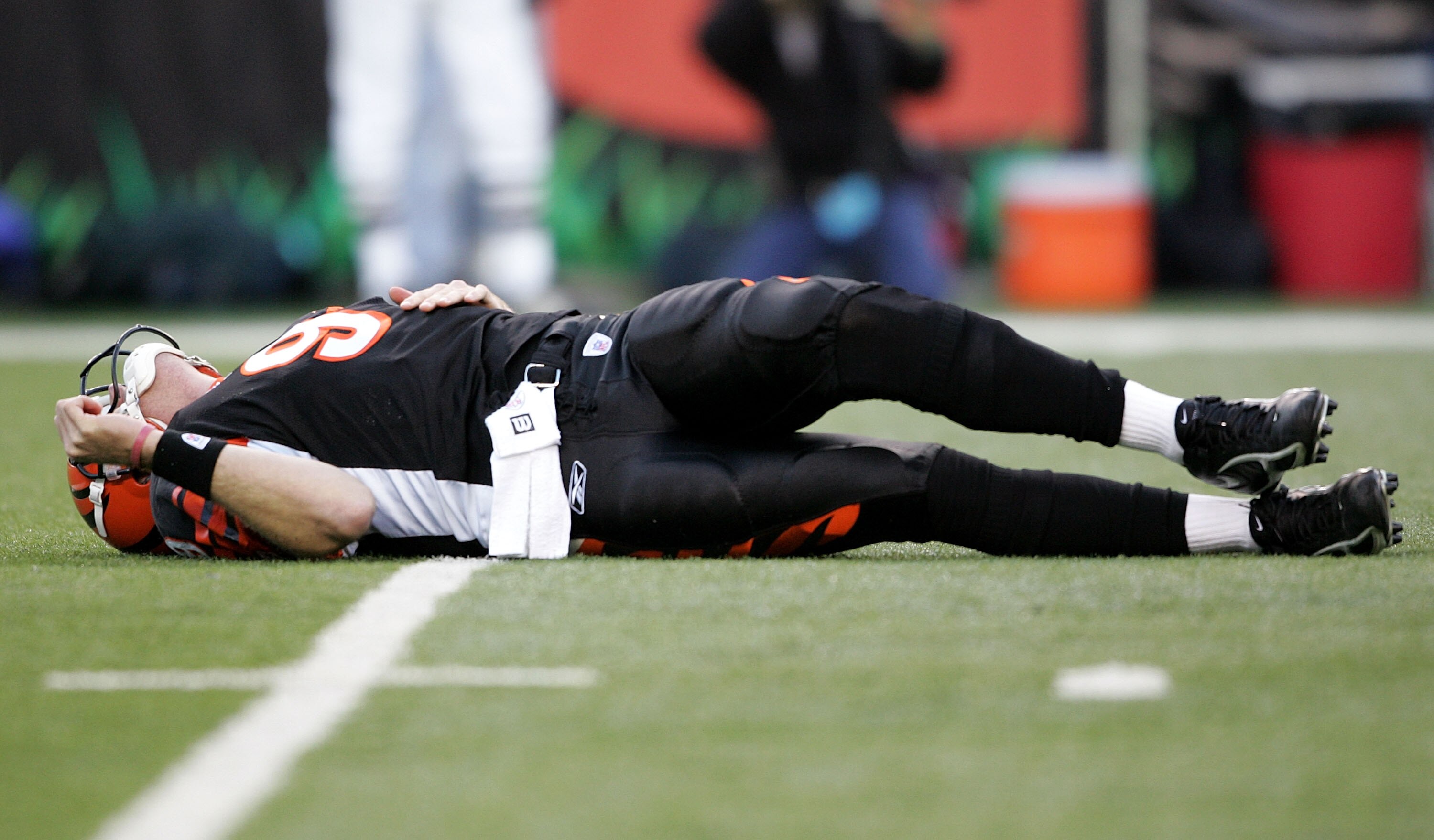 CINCINNATI - JANUARY 08:  Quarterback Carson Palmer #9 of the Cincinnati Bengals lays on the ground after being hit in the knee on the first drive of the AFC Wild Card Playoff Game against the Pittsburgh Steelers at Paul Brown Stadium on January 8, 2006 i