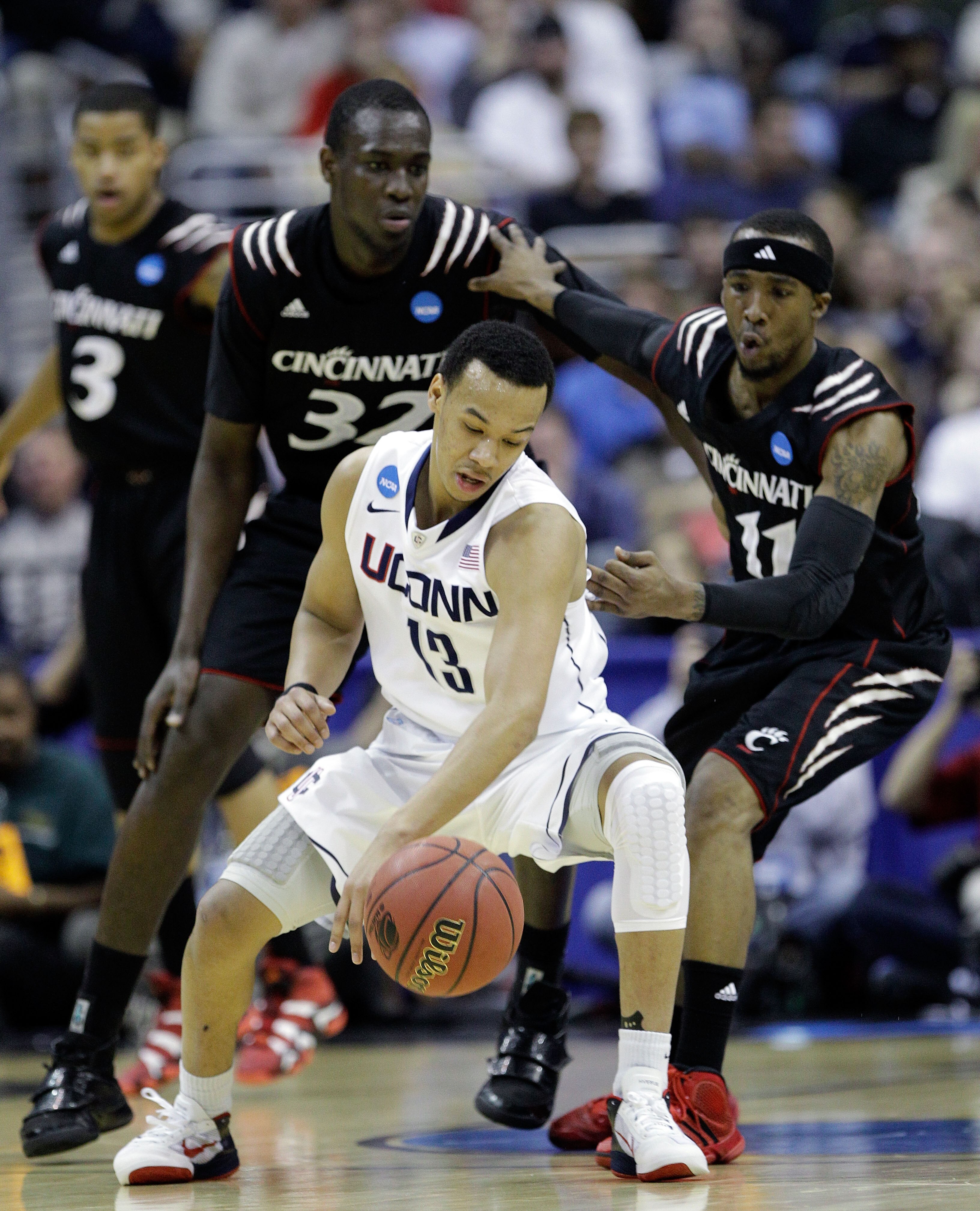 WASHINGTON - MARCH 19:  Shabazz Napier #13 of the Connecticut Huskies keeps the ball from Ibrahima Thomas #32 and Larry Davis #11 of the Cincinnati Bearcats during the third round of the 2011 NCAA men's basketball tournament at Verizon Center on March 19,