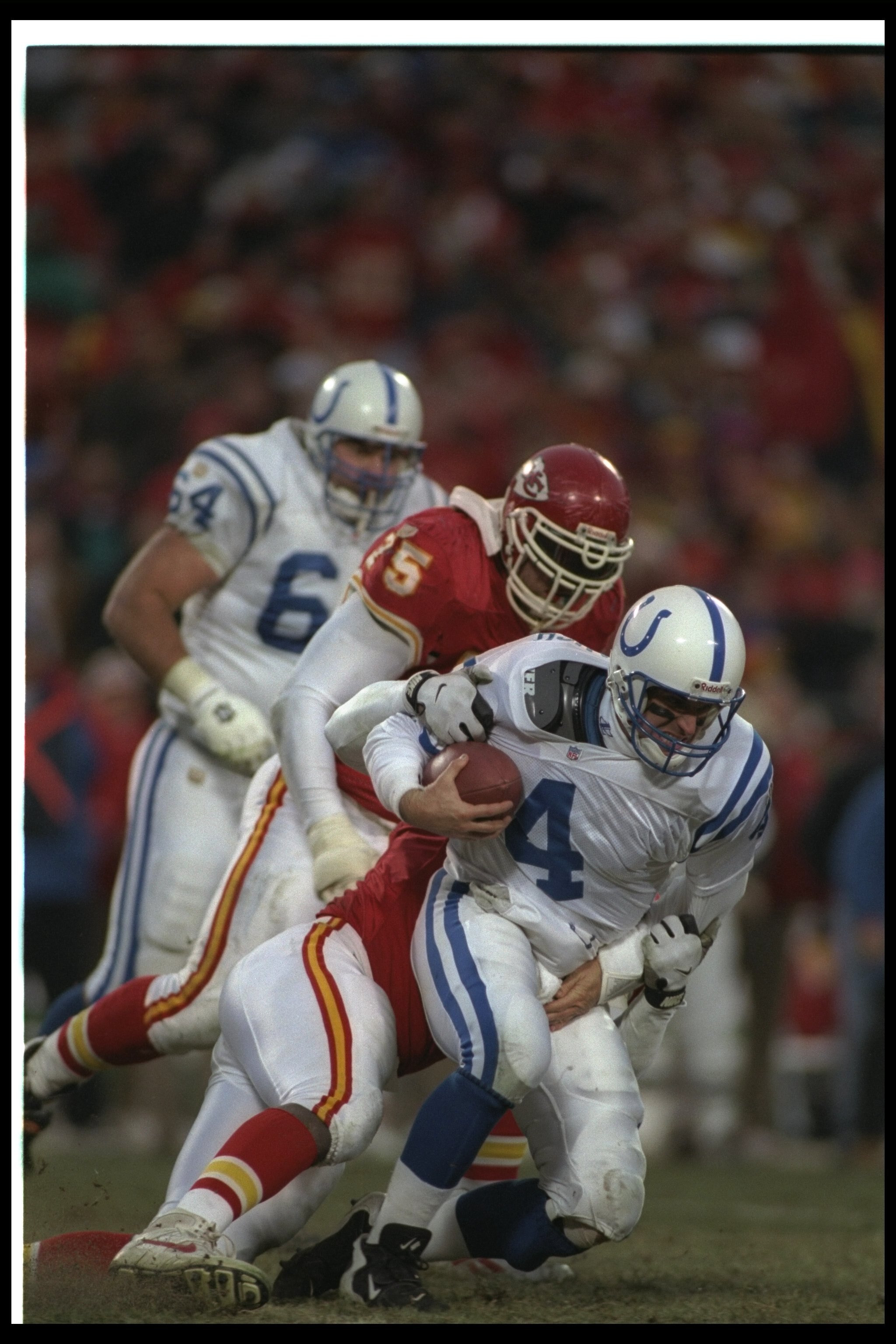 15 Dec 1996: Quarterback Jim Harbaugh of the Indianapolis Colts gets tackled by a Kansas City Chiefs player during a game at Arrowhead Stadium in Kansas City, Missouri. The Colts won the game, 24-19.