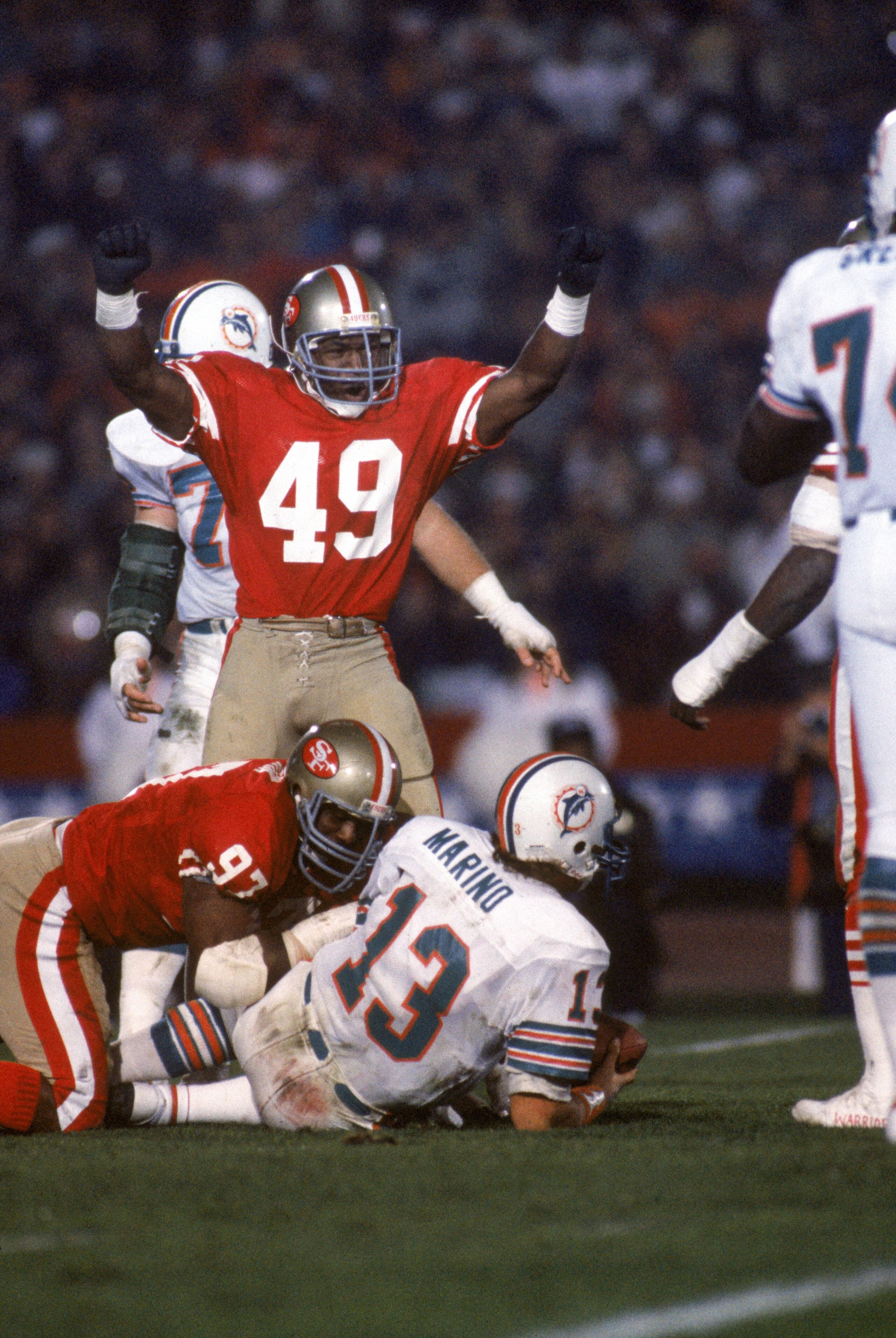 STANFORD, CA - JANUARY 20: Linebacker Jeff Fuller #49 of the San Francisco 49ers celebrates after teaming up with teammate Gary Johnson #97 on a sack against Miami Dolphins quarterback Dan Marino #13 during Super Bowl XIX at Stanford Stadium on January 2 STANFORD, CA - JANUARY 20: Linebacker Jeff Fuller #49 of the San Francisco 49ers celebrates after teaming up with teammate Gary Johnson #97 on a sack against Miami Dolphins quarterback Dan Marino #13 during Super Bowl XIX at Stanford Stadium on January 2