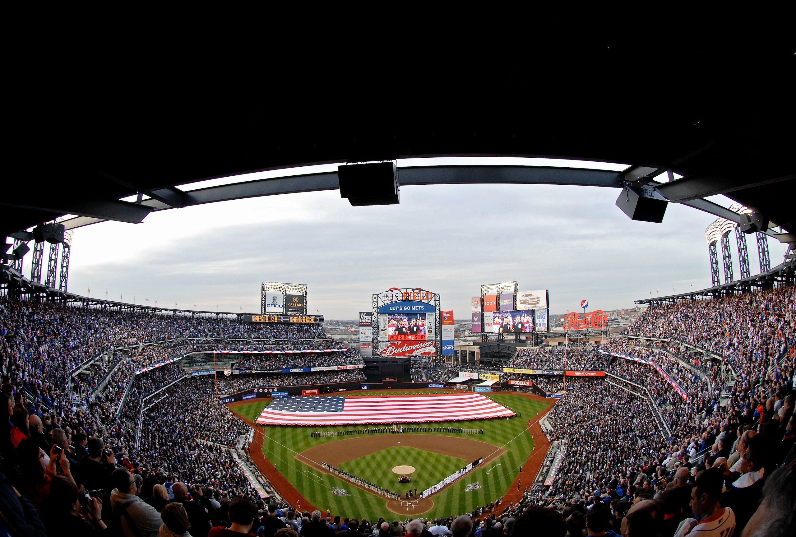NEW YORK - APRIL 13: Members of the U.S. military hold a giant flag on the field as the National Anthem is performed prior to the start of the opening day game between the San Diego Padres and the New York Mets at Citi Field on April 13, 2009 in the Flush