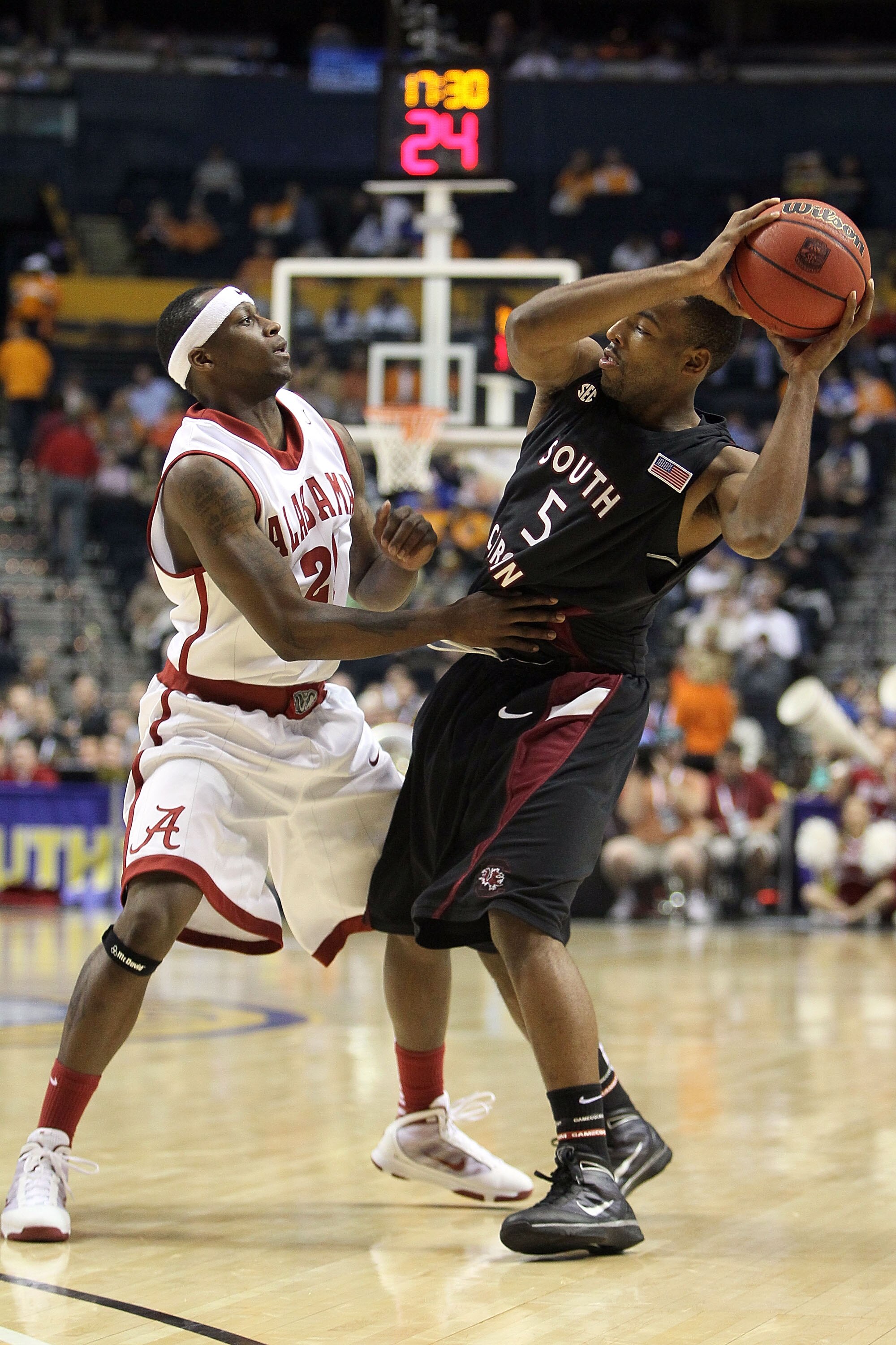 NASHVILLE, TN - MARCH 11:  Brandis Raley-Ross #5 of the South Carolina Gamecocks looks to pass against Senario Hillman #21 of the Alabama Crimson Tide during the first round of the SEC Men's Basketball Tournament at the Bridgestone Arena on March 11, 2010