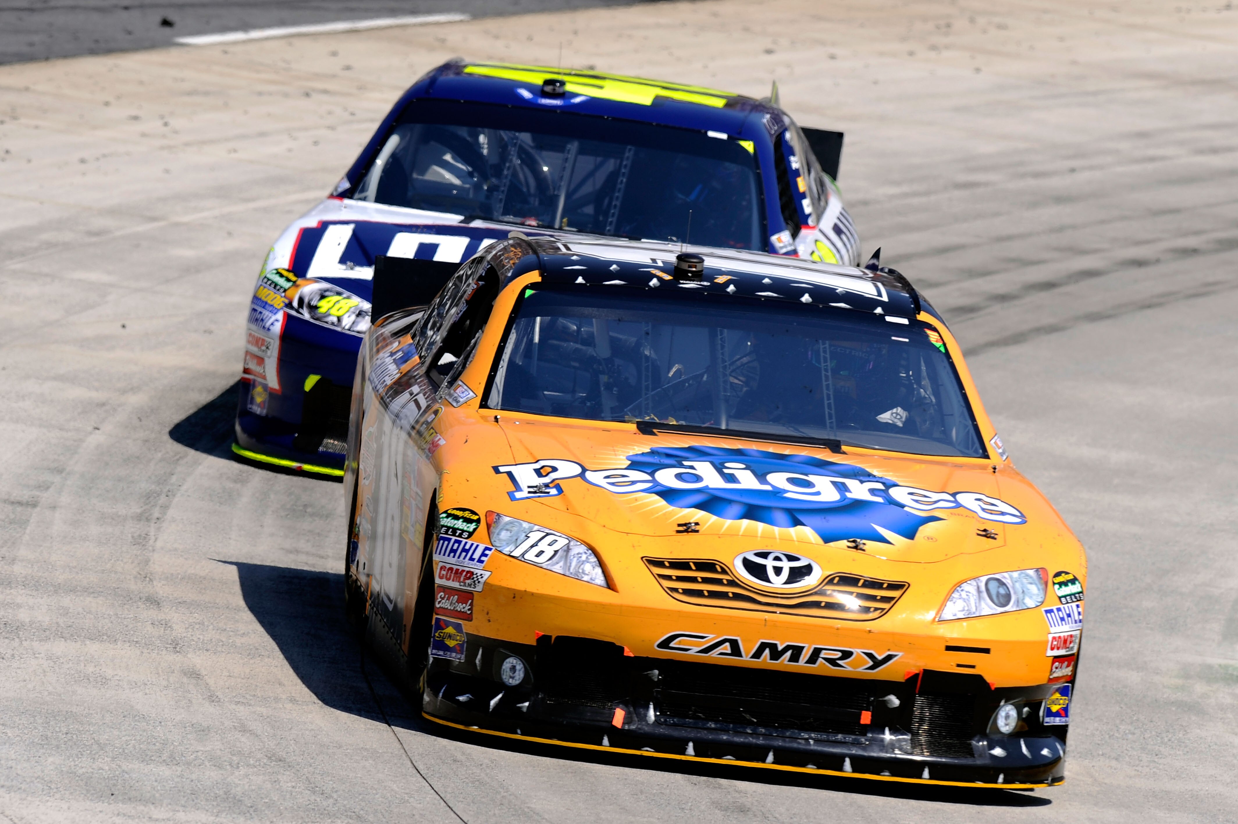 MARTINSVILLE, VA - APRIL 03:  Kyle Busch, driver of the #18 Pedigree Toyota, leads Jimmie Johnson, driver of the #48 Lowe's Chevrolet, during the NASCAR Sprint Cup Series Goody's Fast Relief 500 at Martinsville Speedway on April 3, 2011 in Martinsville, V