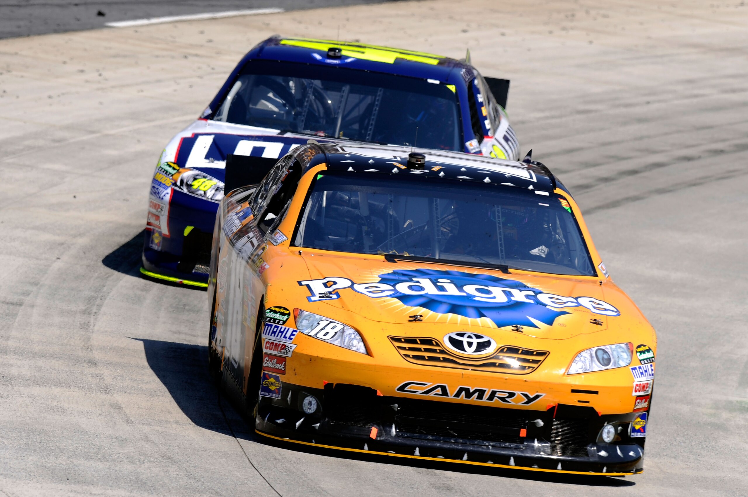 MARTINSVILLE, VA - APRIL 03:  Kyle Busch, driver of the #18 Pedigree Toyota, leads Jimmie Johnson, driver of the #48 Lowe's Chevrolet, during the NASCAR Sprint Cup Series Goody's Fast Relief 500 at Martinsville Speedway on April 3, 2011 in Martinsville, V