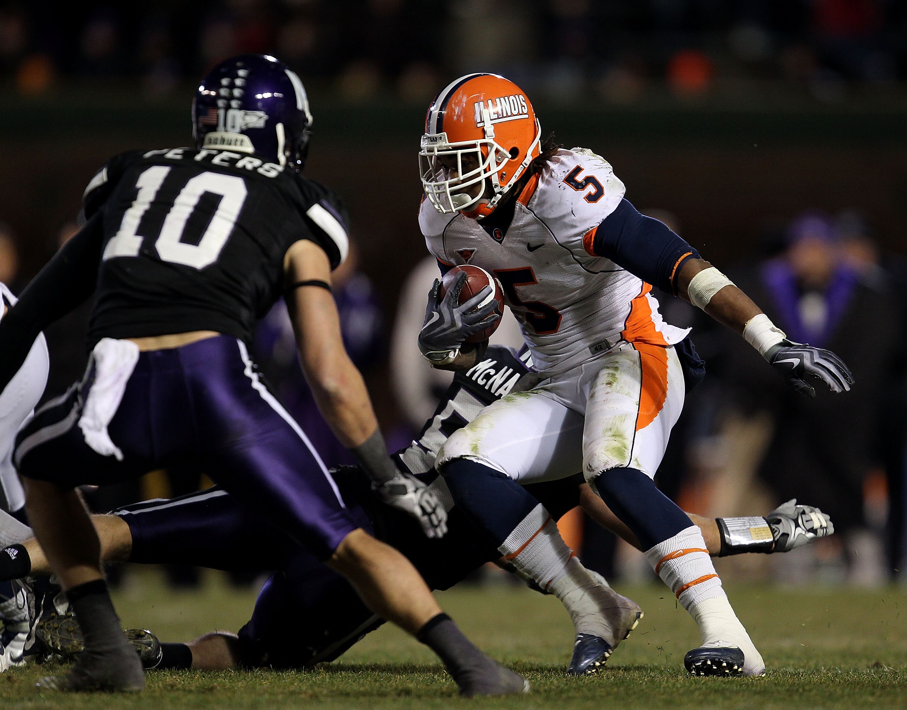 CHICAGO - NOVEMBER 20: Mikel Leshoure #5 of the Illinois Fighting Illini runs as Brian Peters #10 of the Northwestern Wildcats closes in during a game played at Wrigley Field on November 20, 2010 in Chicago, Illinois. Illinois defeated Northwestern 48-27.