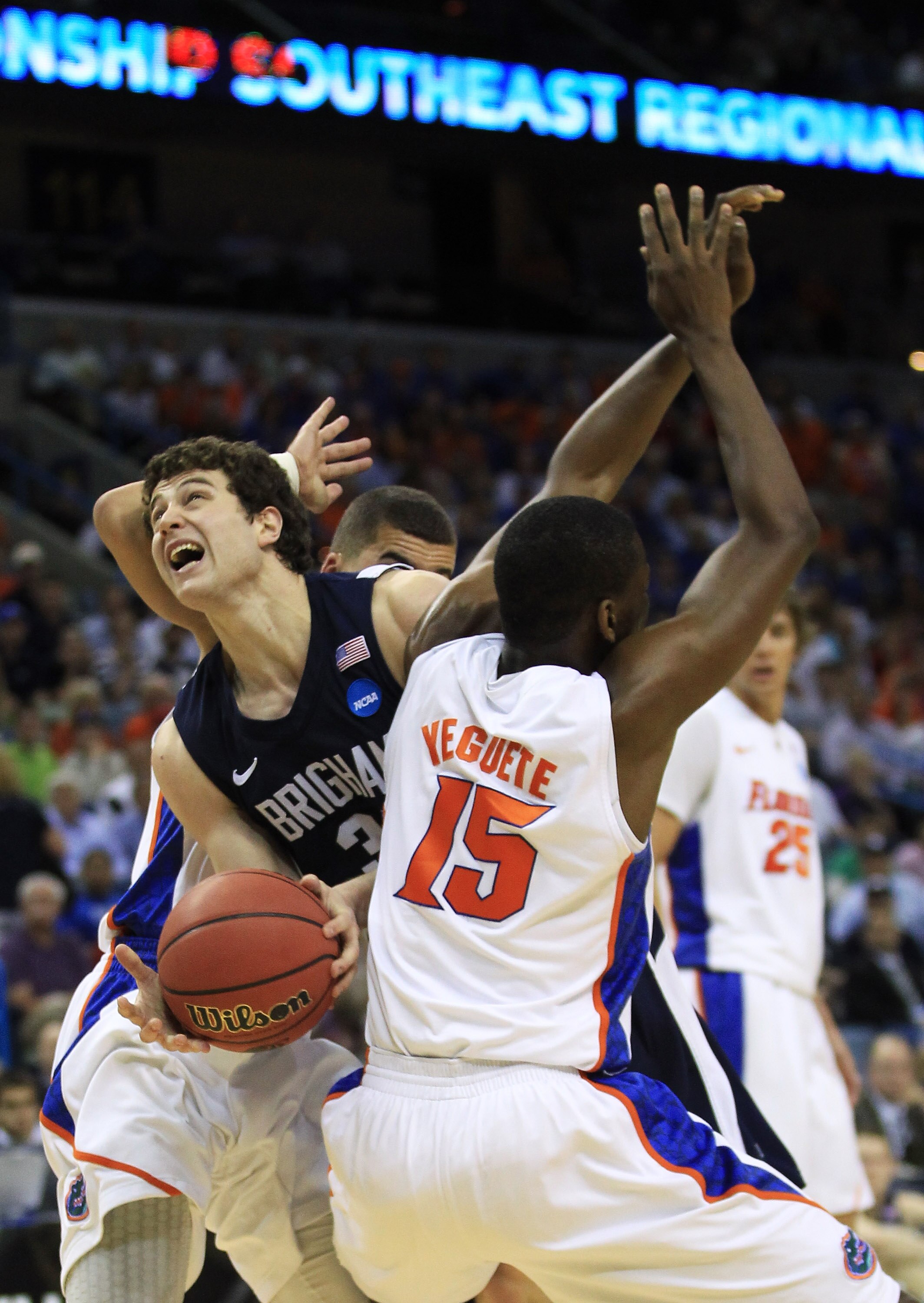 NEW ORLEANS, LA - MARCH 24:  Jimmer Fredette #32 of the Brigham Young Cougars is blocked Brigham Young Cougars Scottie Wilbekin #5 and Will Yeguete #15 of the Florida Gators in the second half during the Southeast regional of the 2011 NCAA men's basketbal