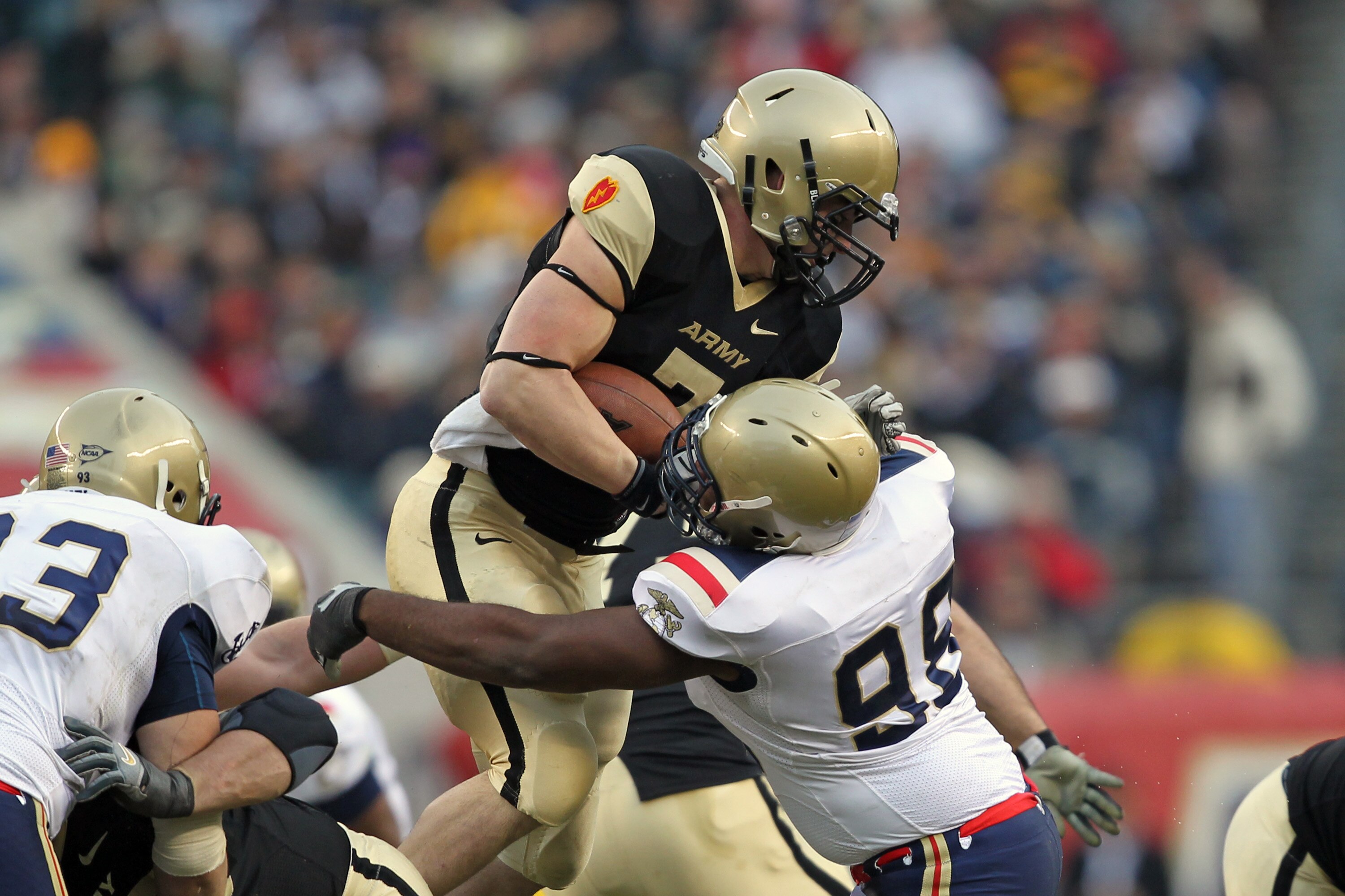 PHILADELPHIA - DECEMBER 11: Running back Jared Hassin #7 of the Army Black Knights is tackled by defensive end Jabaree Tuani #98 of the Navy Midshipmen during a game on December 11, 2010 at Lincoln Financial Field in Philadelphia, Pennsylvania. The Midshi