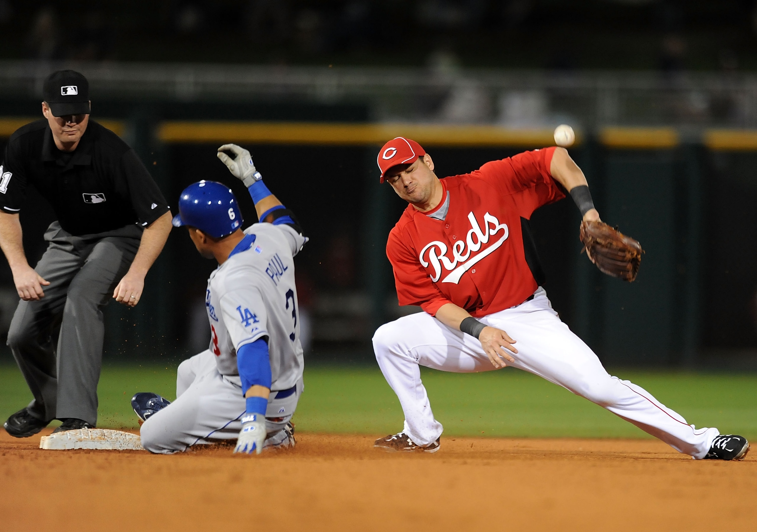 GOODYEAR, AZ - MARCH 03:  Xavier Paul #3 of the Los Angeles Dodgers slides into second base as Paul Janish #7 of the Cincinnati Reds cannot come up with the ball at Goodyear Ballpark on March 3, 2011 in Goodyear, Arizona.  (Photo by Norm Hall/Getty Images