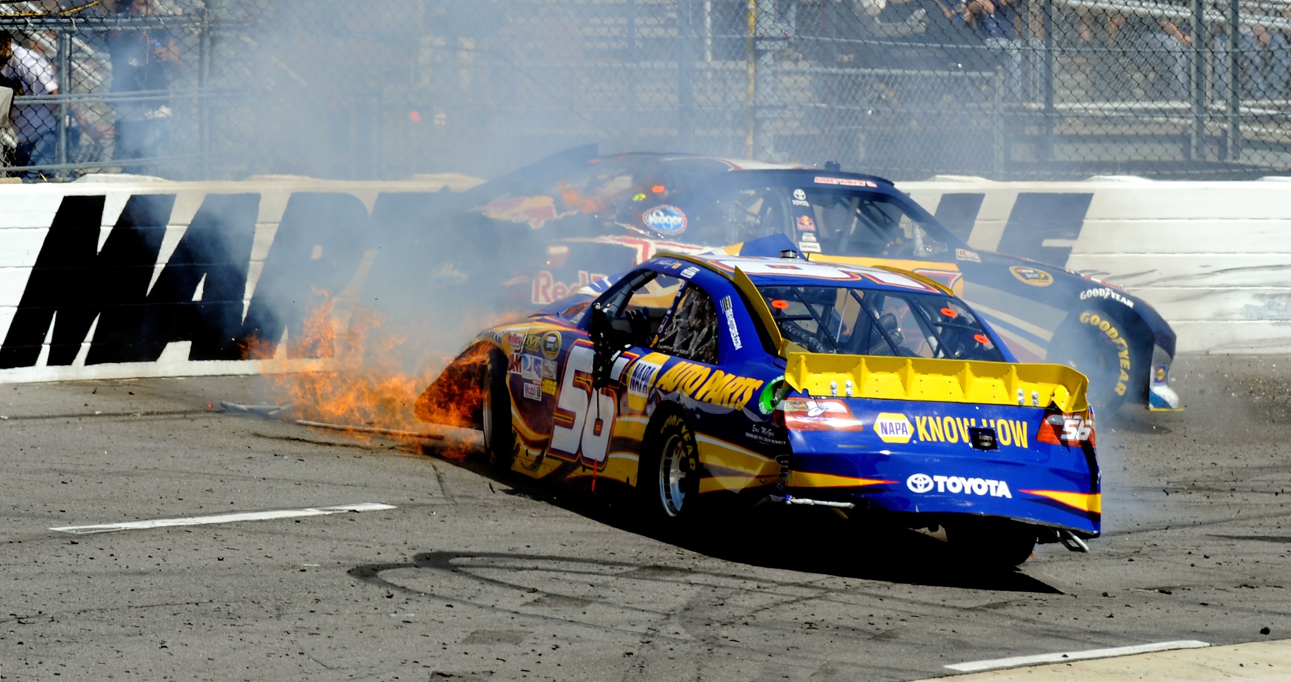 MARTINSVILLE, VA - APRIL 03:  The #56 NAPA Auto Parts Toyota, driven by Martin Truex Jr., catches fire after an incident with Kasey Kahne, driver of the #4 Red Bull Toyota, during the NASCAR Sprint Cup Series Goody's Fast Relief 500 at Martinsville Speedw