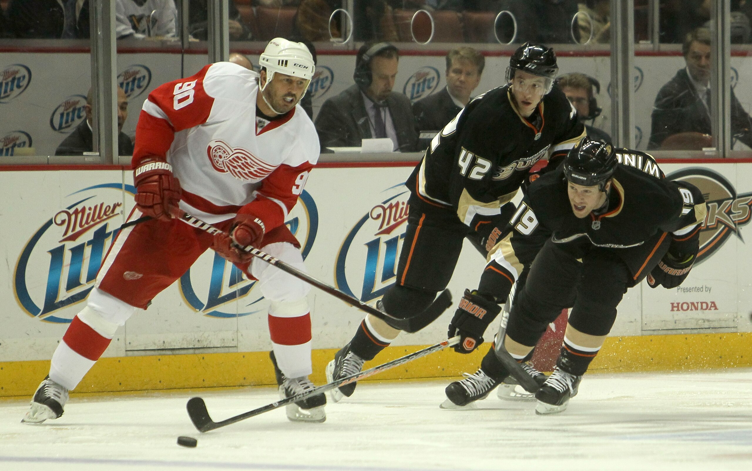 ANAHEIM, CA - MARCH 2:  Brad Winchester #19 of the Anaheim Ducks reaches to win the puck from Mike Modano #90 of the Detroit Red Wings in front of Duck Dan Sexton #42 on March 2, 2011 at the Honda Center in Anaheim, California.   The Ducks won 2-1 in over