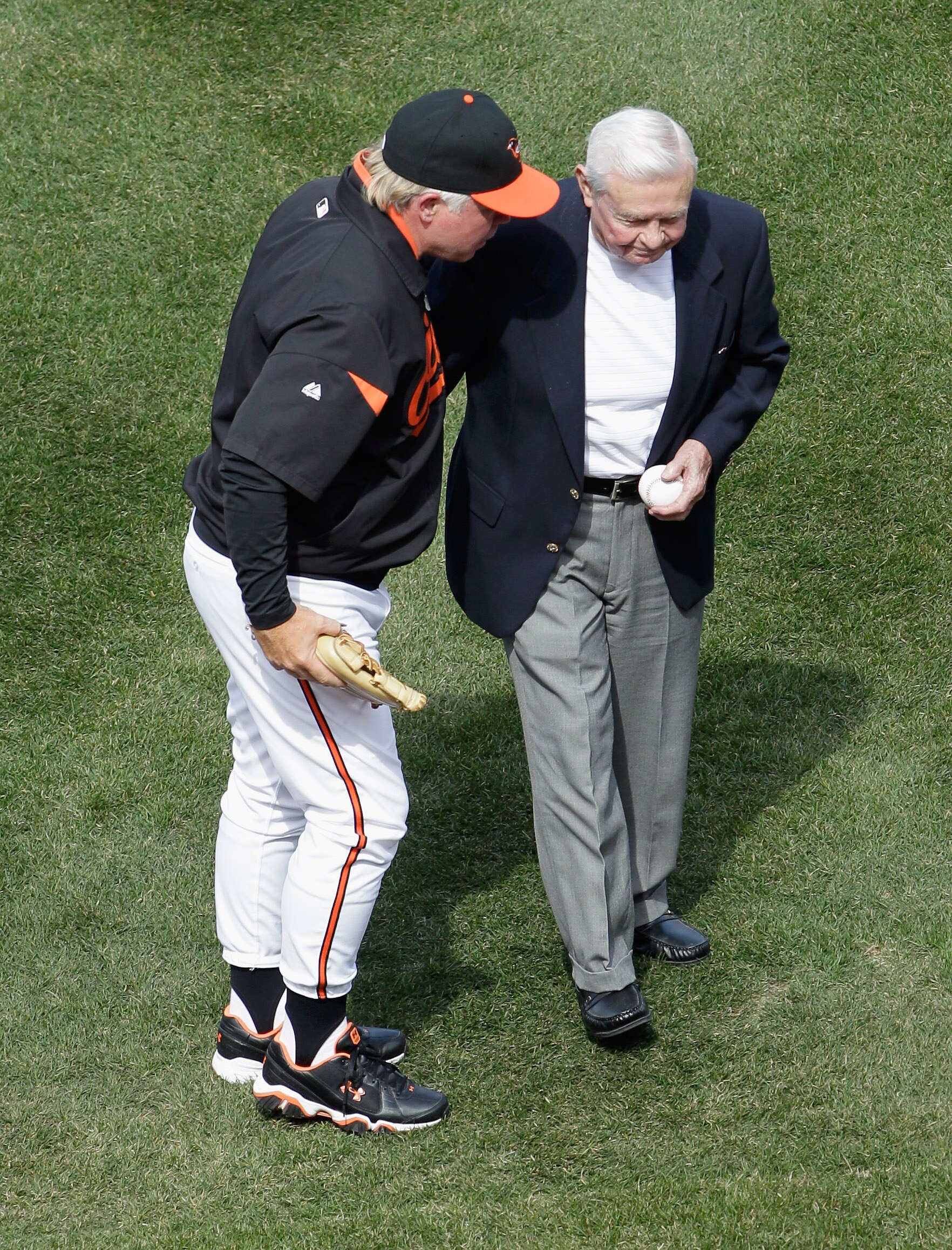 BALTIMORE, MD - APRIL 04: Buck Showalter #26 manager of the Baltimore Orioles talks with former Orioles manager Earl Weaver (R) after Weaver threw out the ceremonial first pitch before the start of their game against the Detroit Tigers  during opening day
