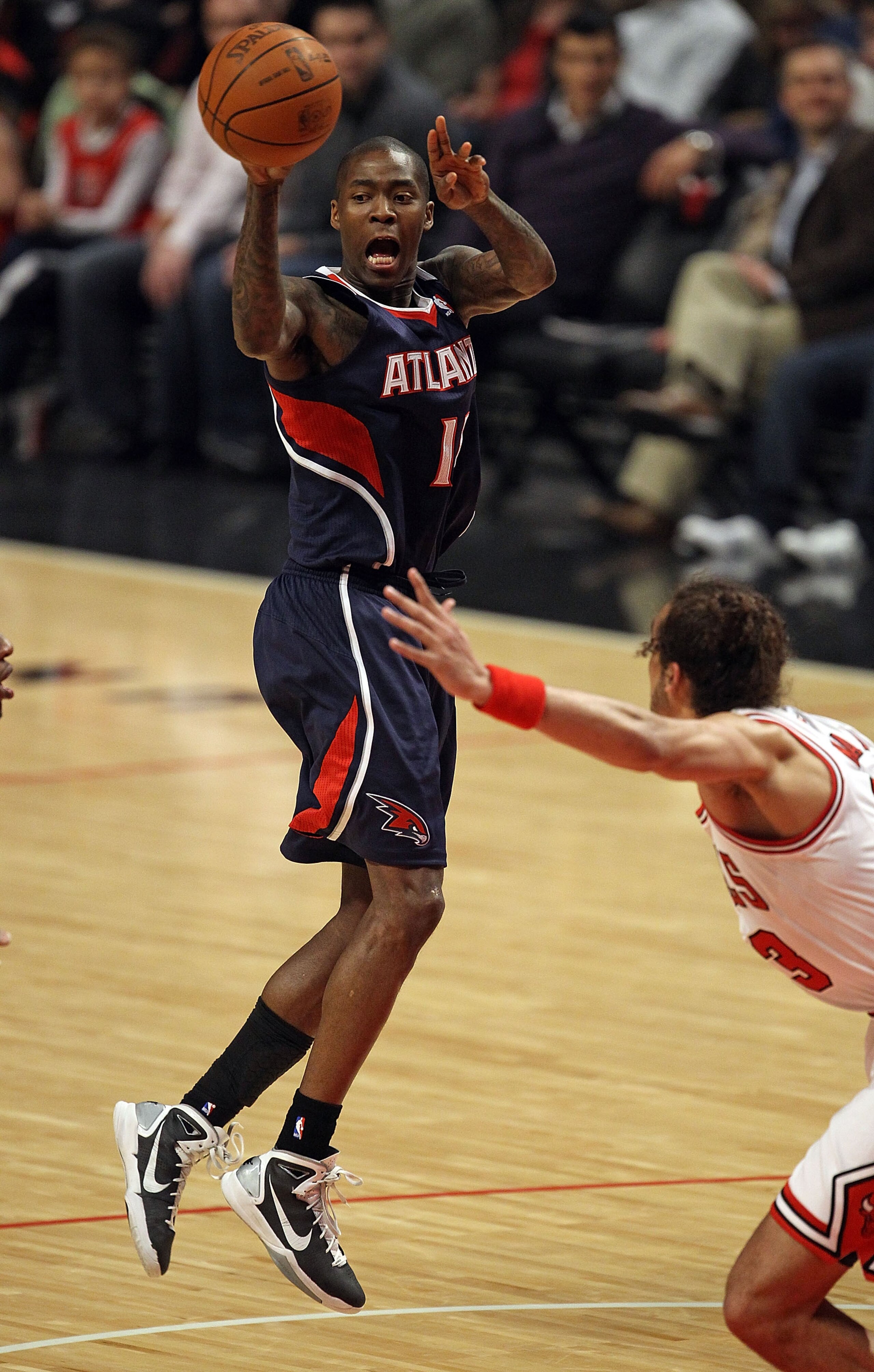 CHICAGO, IL - MARCH 11: Jamal Crawford #11 of the Atlanta Hawks leaps to pass over Joakim Noah #13 of the Chicago Bulls at the United Center on March 11, 2011 in Chicago, Illinois. NOTE TO USER: User expressly acknowledges and agrees that, by downloading