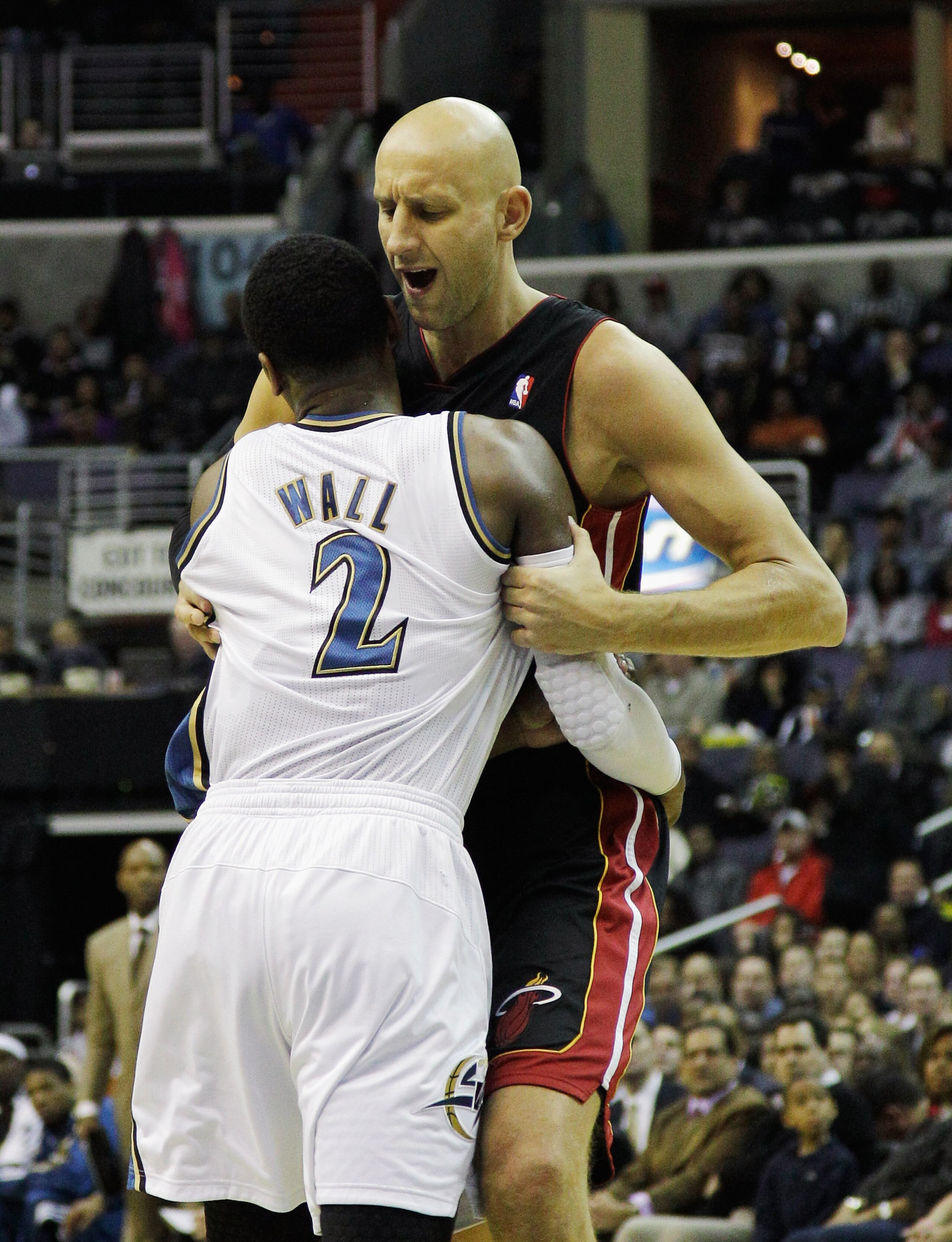WASHINGTON, DC - MARCH 30: Zydrunas Ilgauskas #11 of the Miami Heat and John Wall #2 of the Washington Wizards are involved in a shoving match during the first half at the Verizon Center on March 30, 2011 in Washington, DC.  Ilgauskas, Wall, and Juwan How