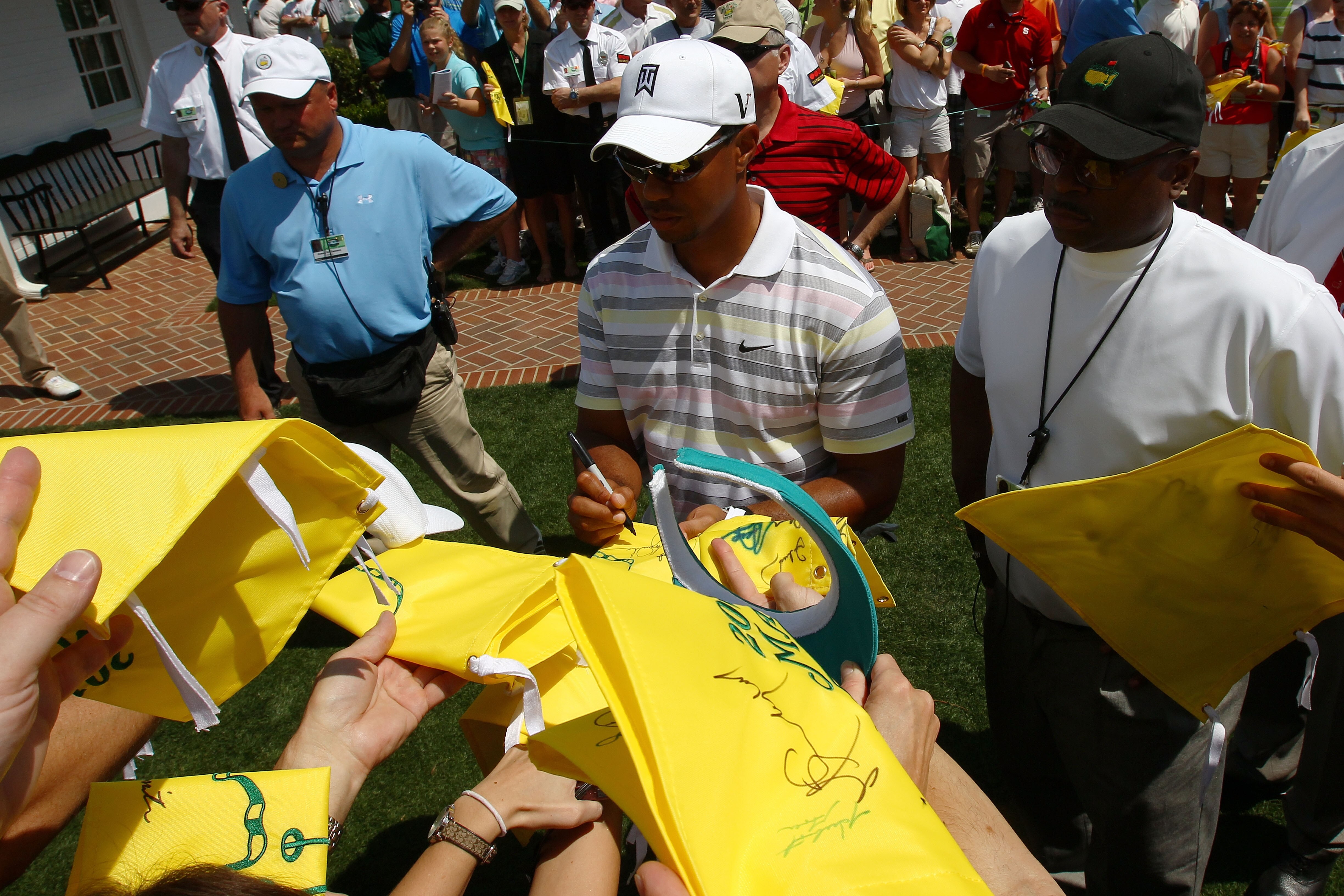 AUGUSTA, GA - APRIL 05:  Tiger Woods signs his autograph for fans as he walks off the practice range during a practice round prior to the 2010 Masters Tournament at Augusta National Golf Club on April 5, 2010 in Augusta, Georgia.  (Photo by Harry How/Gett