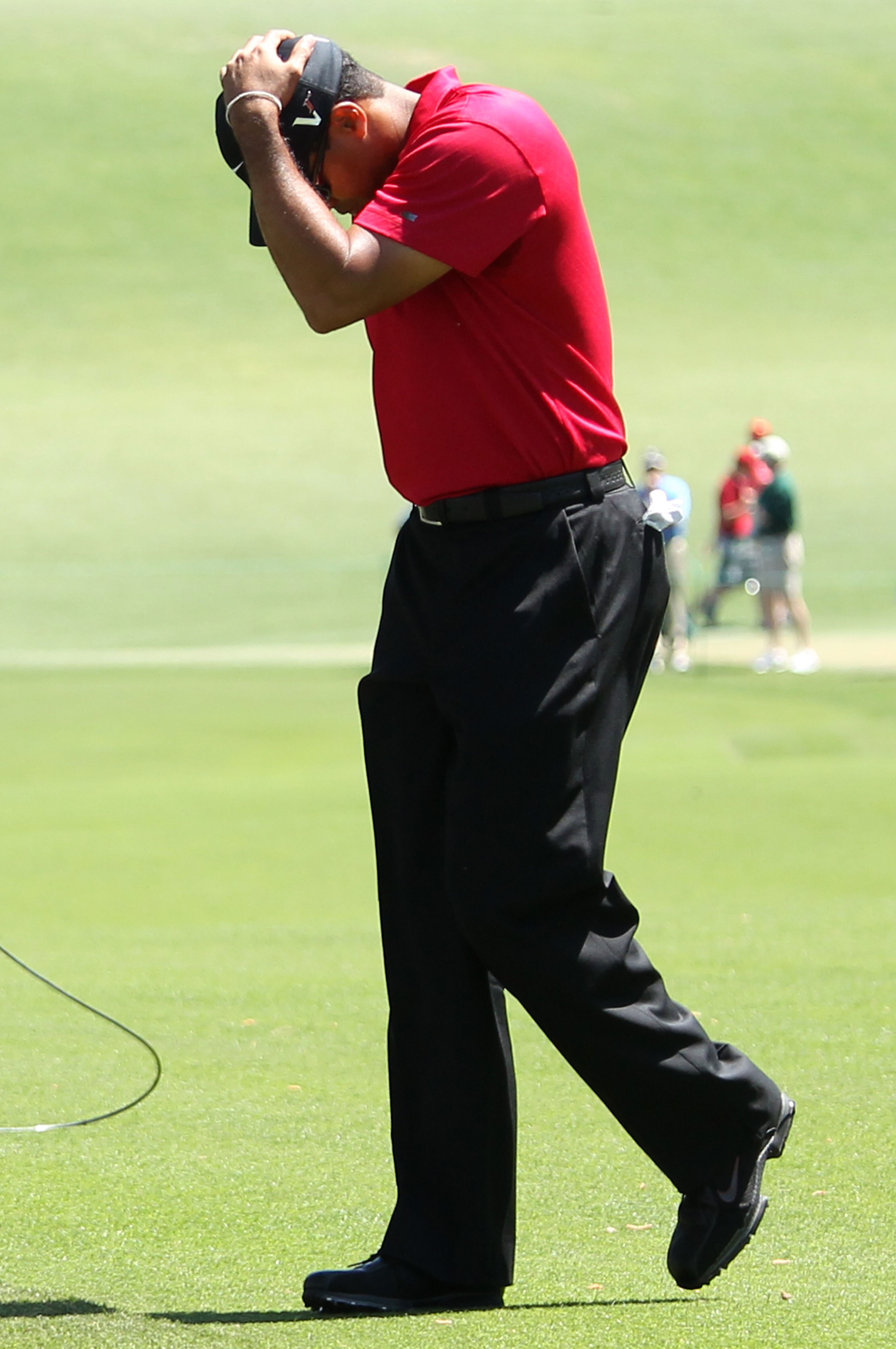 AUGUSTA, GA - APRIL 11:  Tiger Woods reacts to a shot as he plays the first hole during the final round of the 2010 Masters Tournament at Augusta National Golf Club on April 11, 2010 in Augusta, Georgia.  (Photo by Andrew Redington/Getty Images)