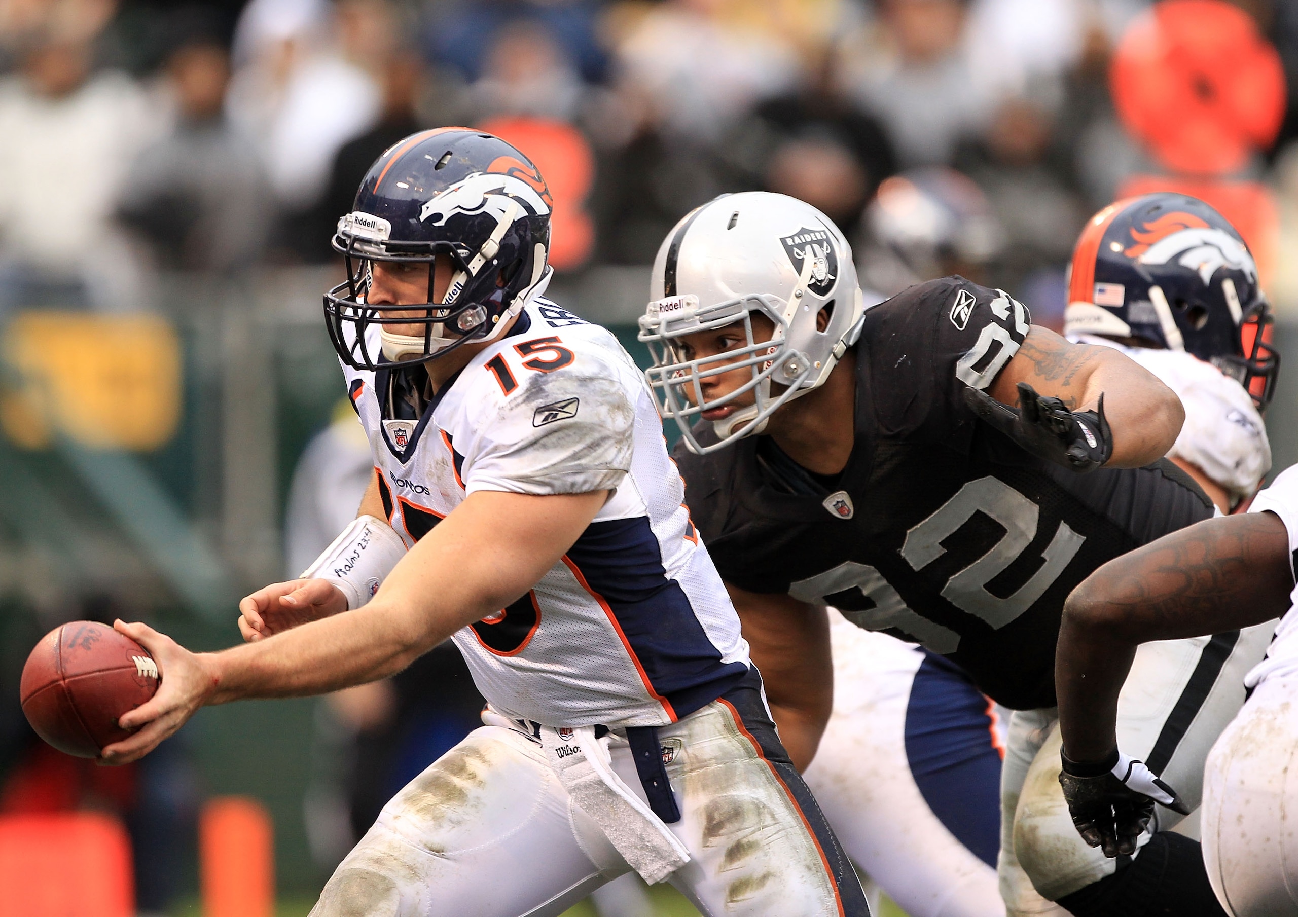 OAKLAND, CA - DECEMBER 19:  Tim Tebow #15 of the Denver Broncos hands off the ball before being hit by Richard Seymour #92 of the Oakland Raiders at Oakland-Alameda County Coliseum on December 19, 2010 in Oakland, California.  (Photo by Ezra Shaw/Getty Im