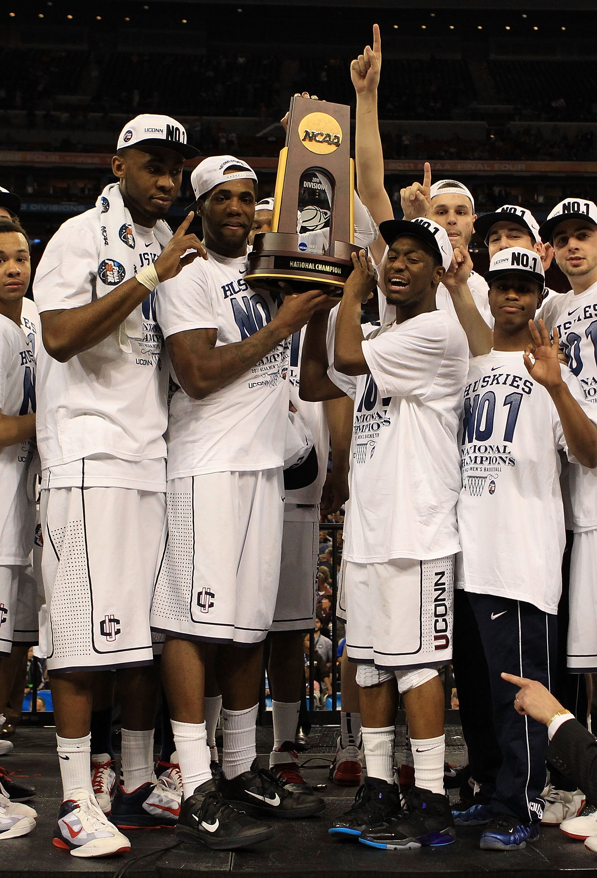 HOUSTON, TX - APRIL 04:  Kemba Walker #15, Alex Oriakhi #34 and Charles Okwandu #35 of the Connecticut Huskies celebrate with the trophy after defeating the Butler Bulldogs to win the National Championship Game of the 2011 NCAA Division I Men's Basketball