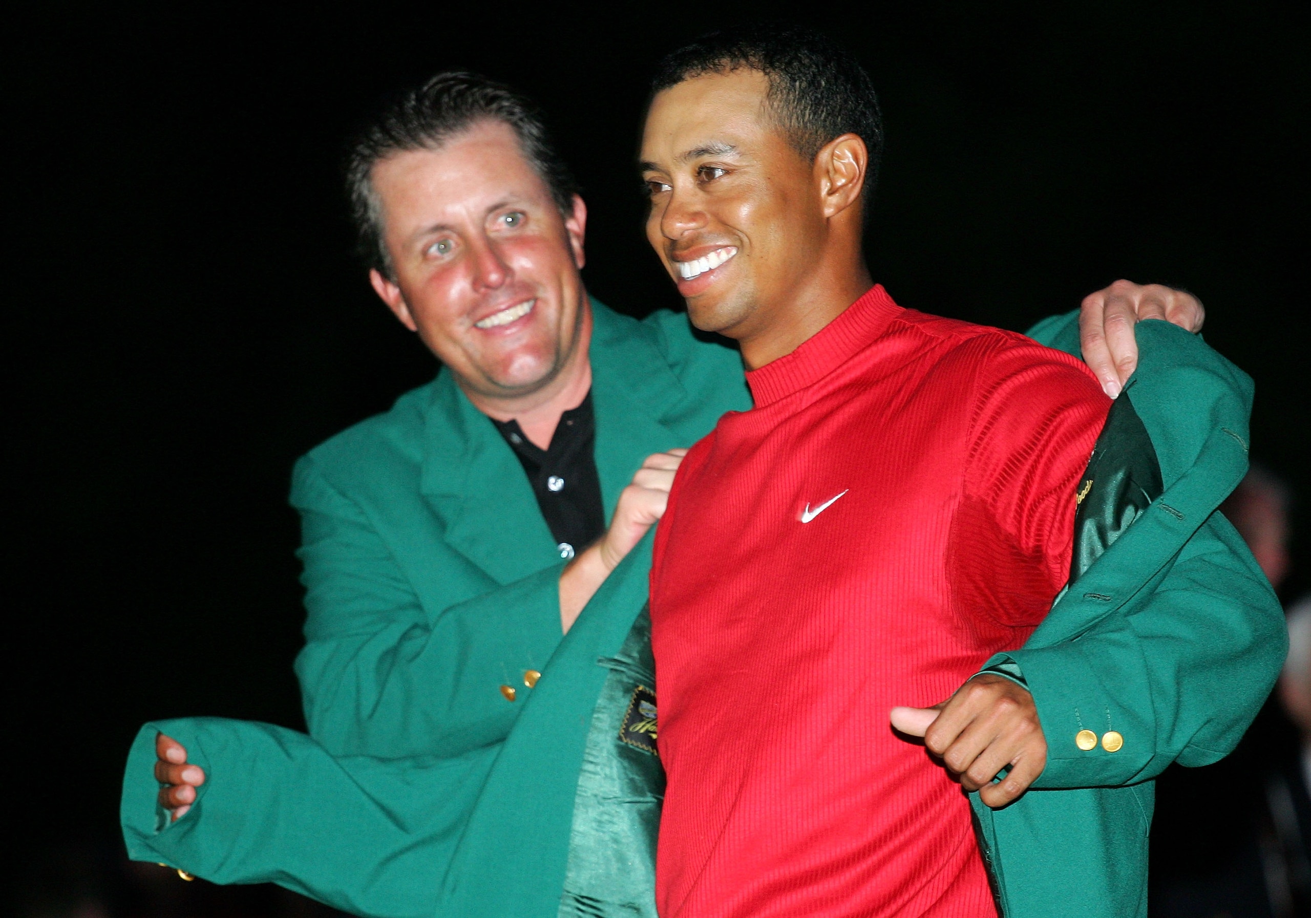 AUGUSTA, GA - APRIL 10: Tiger Woods smiles as he is presented with the green jacket by Phil Mickelson after Woods won The Masters at the Augusta National Golf Club on April 10, 2005 in Augusta, Georgia. (Photo by Harry How/Getty Images) AUGUSTA, GA - APRIL 10: Tiger Woods smiles as he is presented with the green jacket by Phil Mickelson after Woods won The Masters at the Augusta National Golf Club on April 10, 2005 in Augusta, Georgia. (Photo by Harry How/Getty Images)