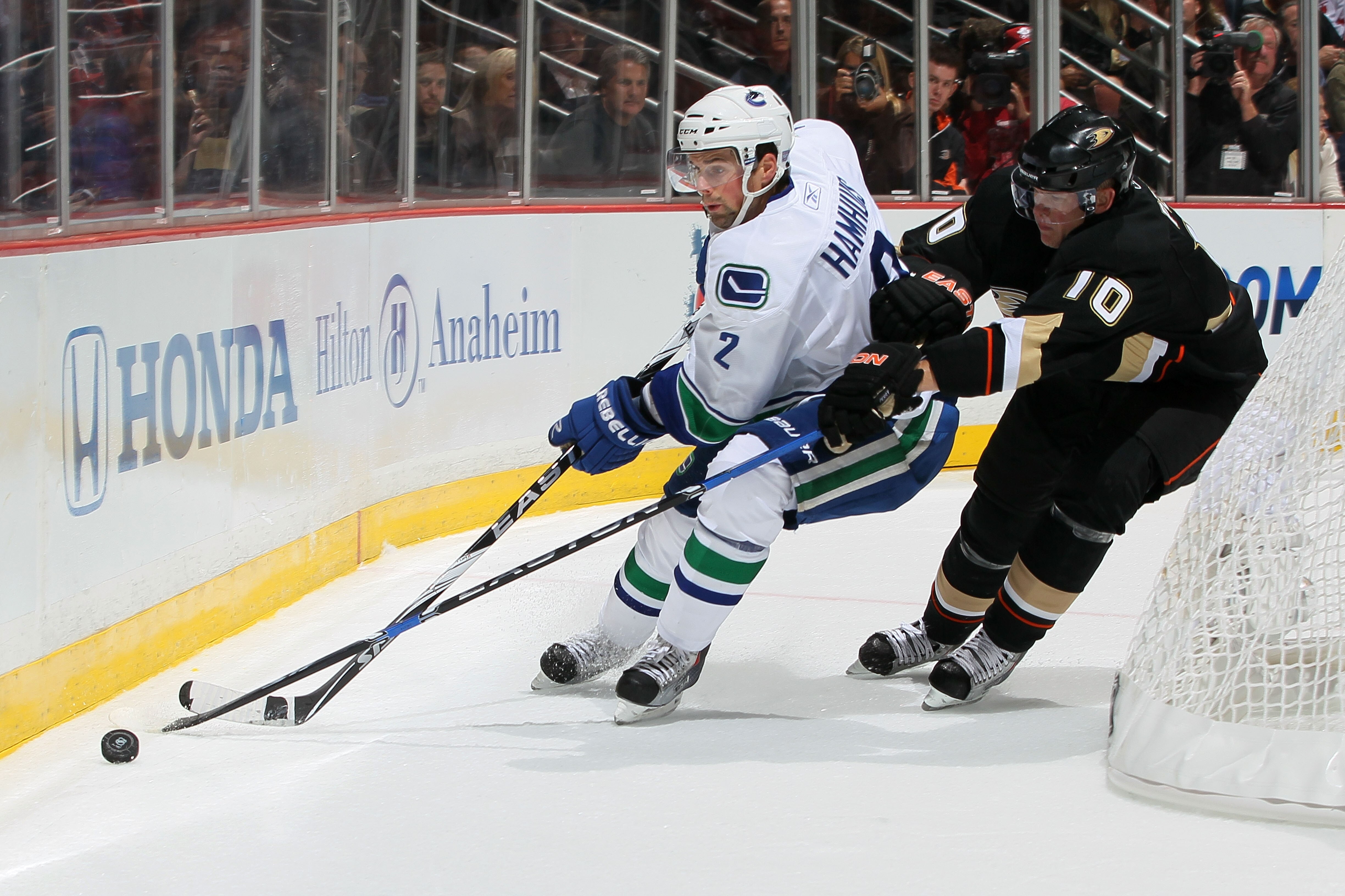 ANAHEIM, CA - OCTOBER 13:  Dan Hamhuis #2 of the Vancouver Canucks fights for possession of the puck with Corey Perry #10 of the Anaheim Ducks at Honda Center on October 13, 2010 in Anaheim, California.  (Photo by Jeff Gross/Getty Images)