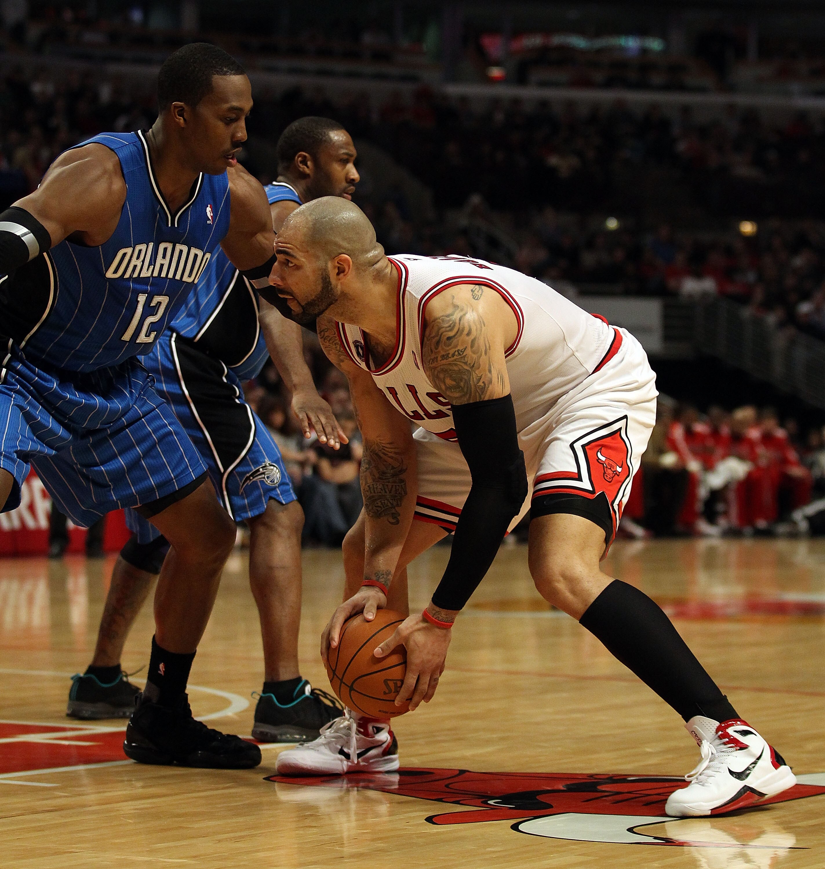 CHICAGO, IL - JANUARY 28: Carlos Boozer #5 of the Chicago Bulls prepares to move against Dwight Howard #12 of the Orlando Magic at the United Center on January 28, 2011 in Chicago, Illinois. The Bulls defeated the Magic 99-90. NOTE TO USER: User expressly