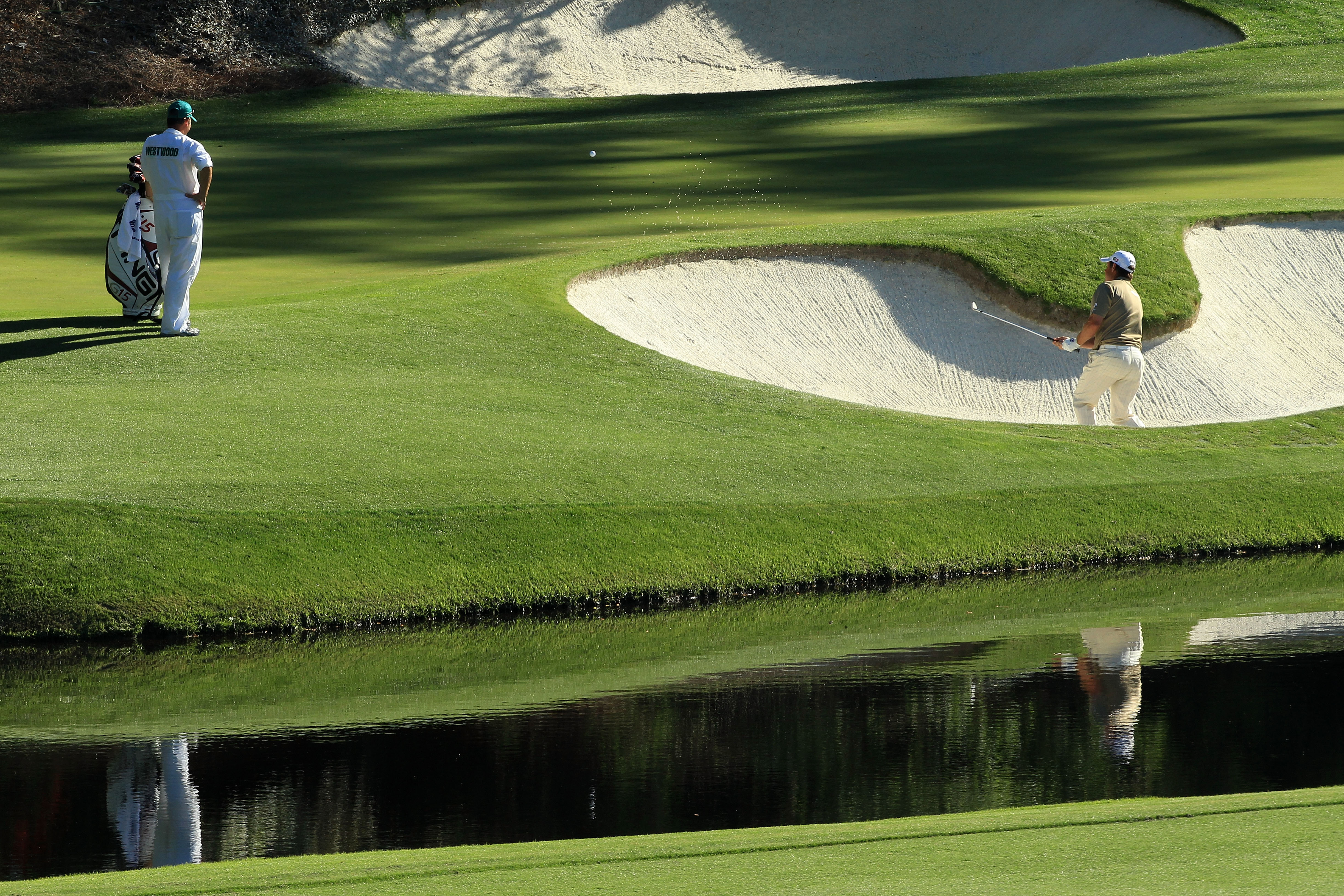 AUGUSTA, GA - APRIL 10:  Lee Westwood of England plays a bunker on the 12th hole as his caddie Billy Foster looks on during the third round of the 2010 Masters Tournament at Augusta National Golf Club on April 10, 2010 in Augusta, Georgia.  (Photo by Davi
