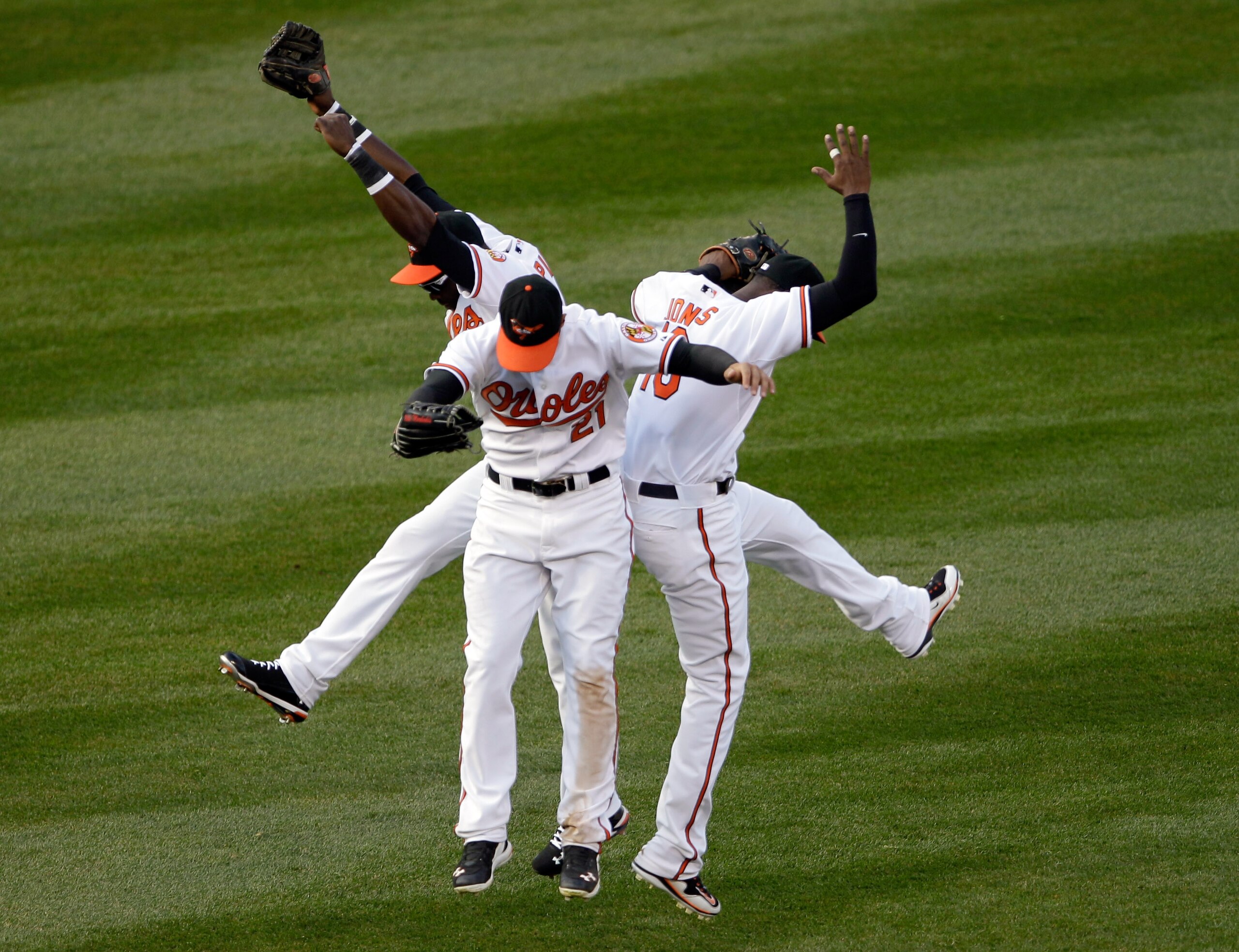 BALTIMORE, MD - APRIL 04: Felix Pie #18 of the Baltimore Orioles (L) and teammates Nick Markakis #21 (C) and Adam Jones #10 celebrate in the outfield after the Orioles defeated the Detroit Tigers 5-1 during opening day at Oriole Park at Camden Yards on Ap