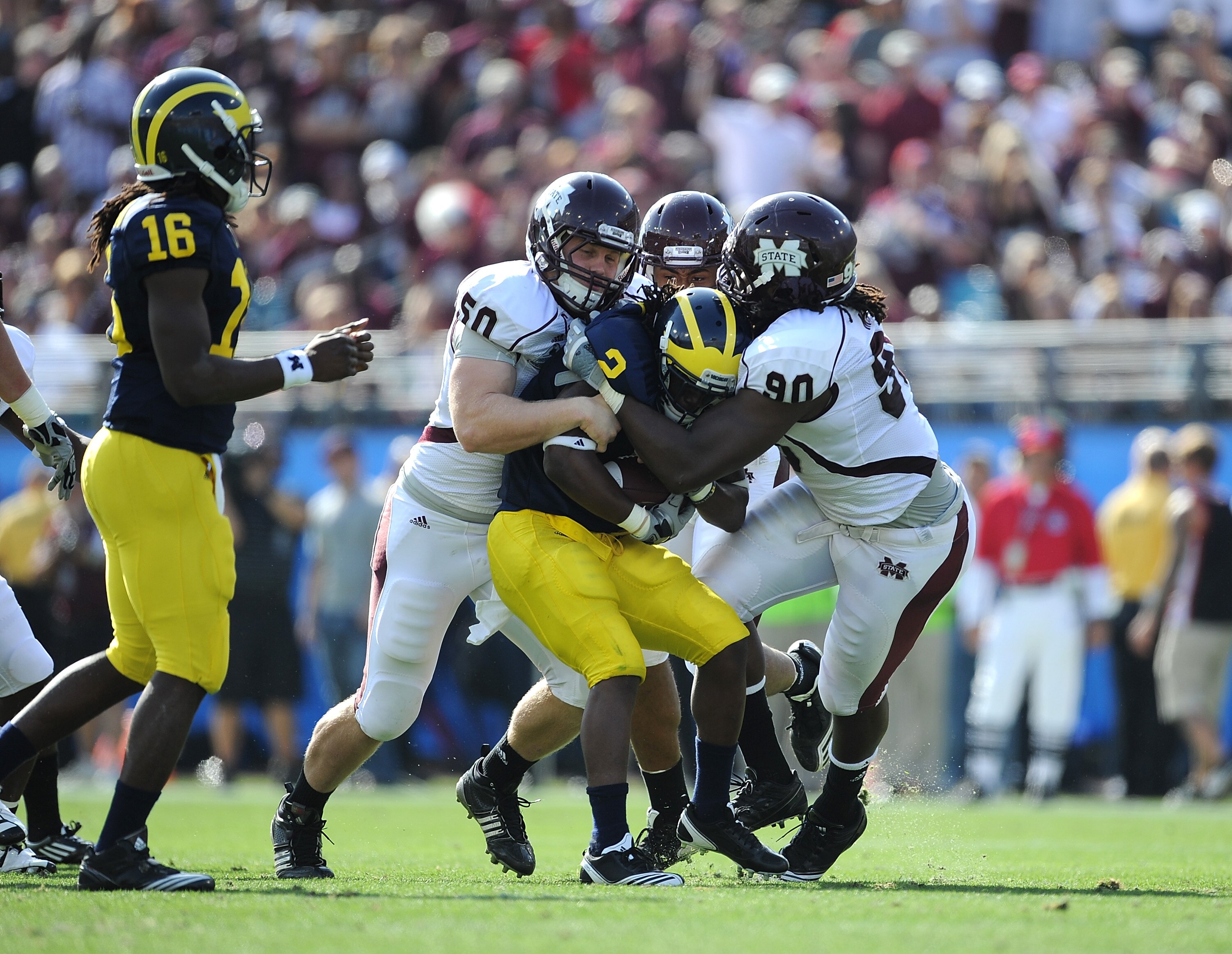 JACKSONVILLE, FL - JANUARY 01:  Chris White #50 and Pernell McPhee #90 of the Mississippi State Bulldogs tackle Vincent Smith # 2 of the Michigan Wolverines during the Gator Bowl at EverBank Field on January 1, 2011 in Jacksonville, Florida  (Photo by Ric