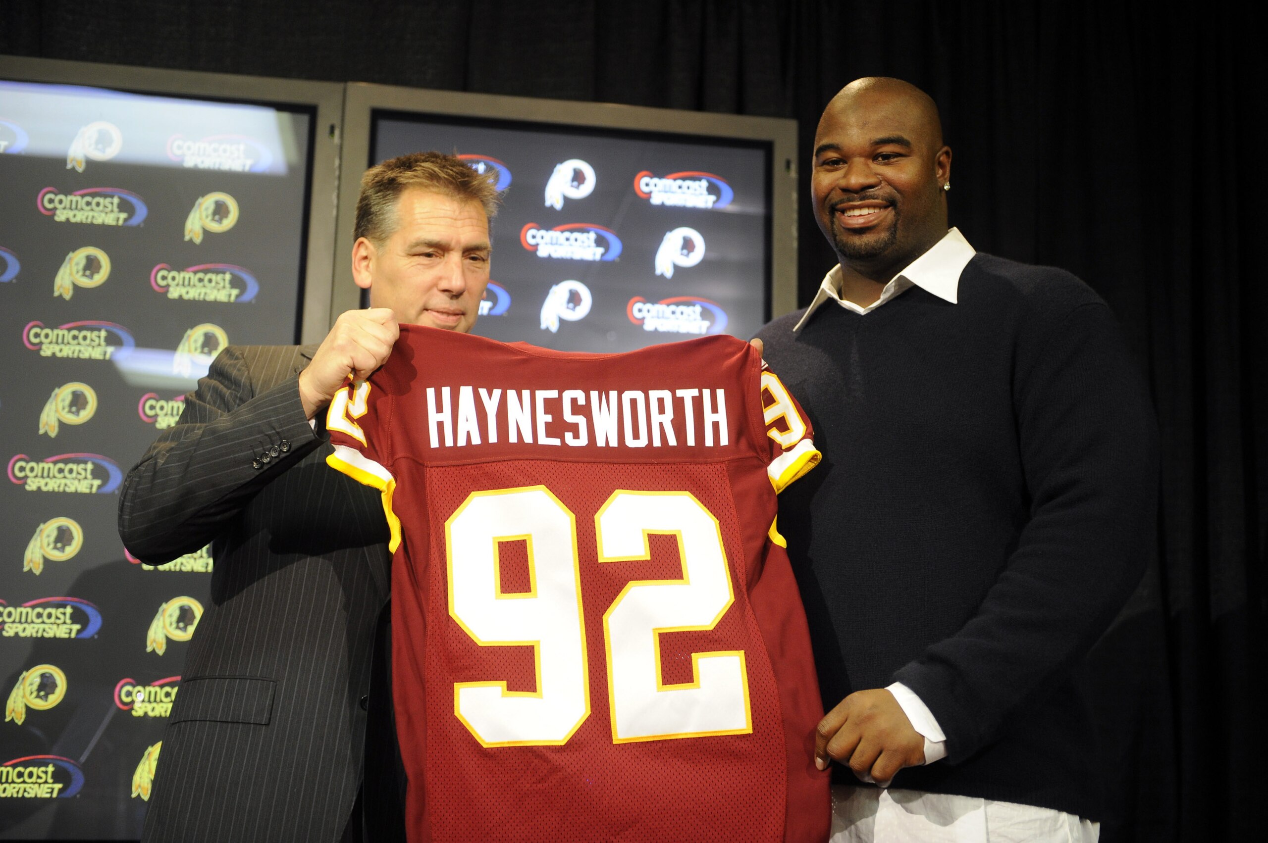 ASHBURN, VA - FEBRUARY 27: Jim Zorn, head coach, presents Albert Haynesworth #92 with a team jersey after signing a 7-year contract worth approximately $100 million with the Washington Redskins on February 27, 2009 at Redskins Park in Ashburn, Virginia. ASHBURN, VA - FEBRUARY 27: Jim Zorn, head coach, presents Albert Haynesworth #92 with a team jersey after signing a 7-year contract worth approximately $100 million with the Washington Redskins on February 27, 2009 at Redskins Park in Ashburn, Virginia.