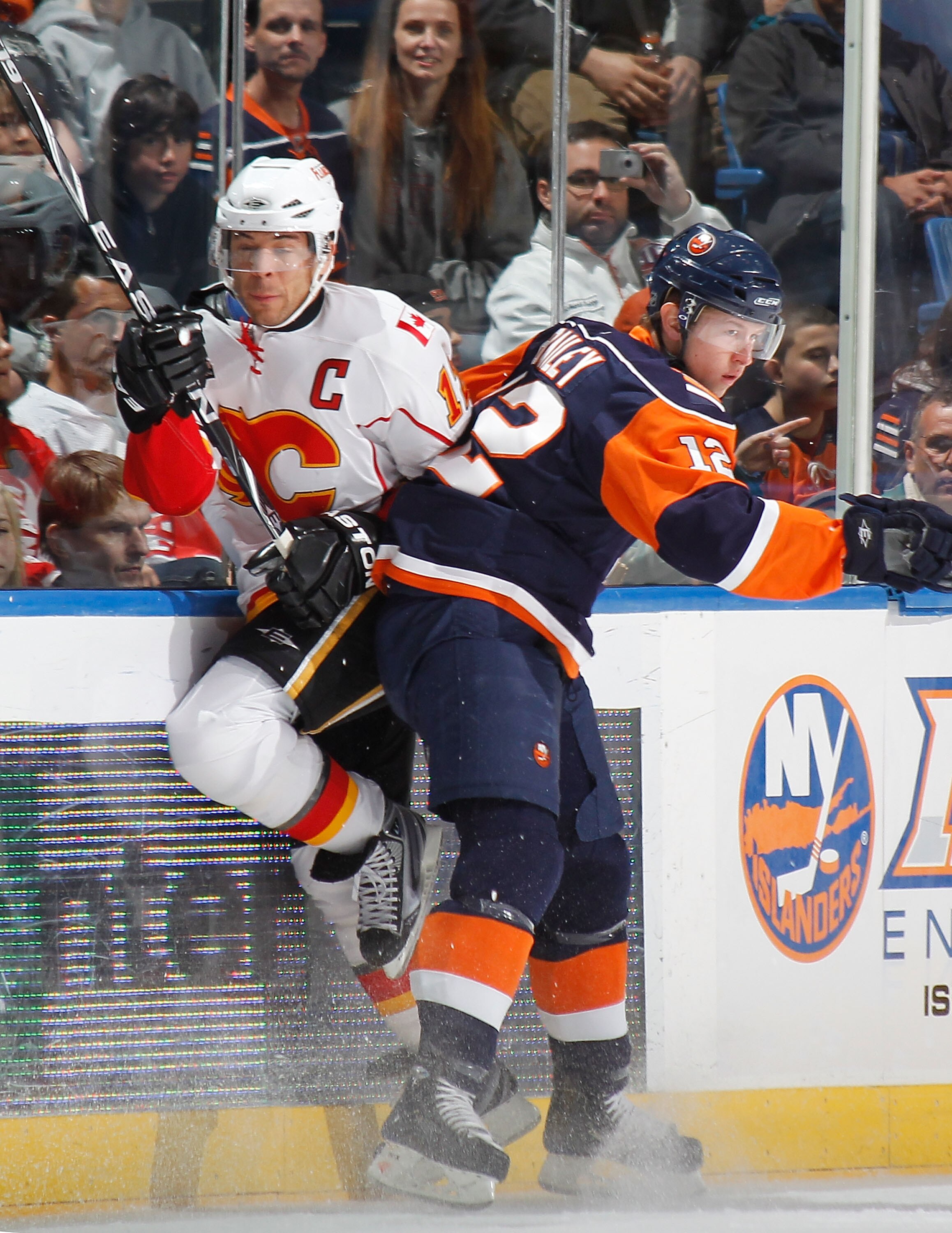 UNIONDALE, NY - MARCH 25:  Jarome Iginla #12 of the Calgary Flames is checked by Josh Bailey #12 of the New York Islanders in the second period of an NHL game at the Nassau Coliseum on March 25, 2010 in Uniondale, New York. The Islanders won 3-2.  (Photo