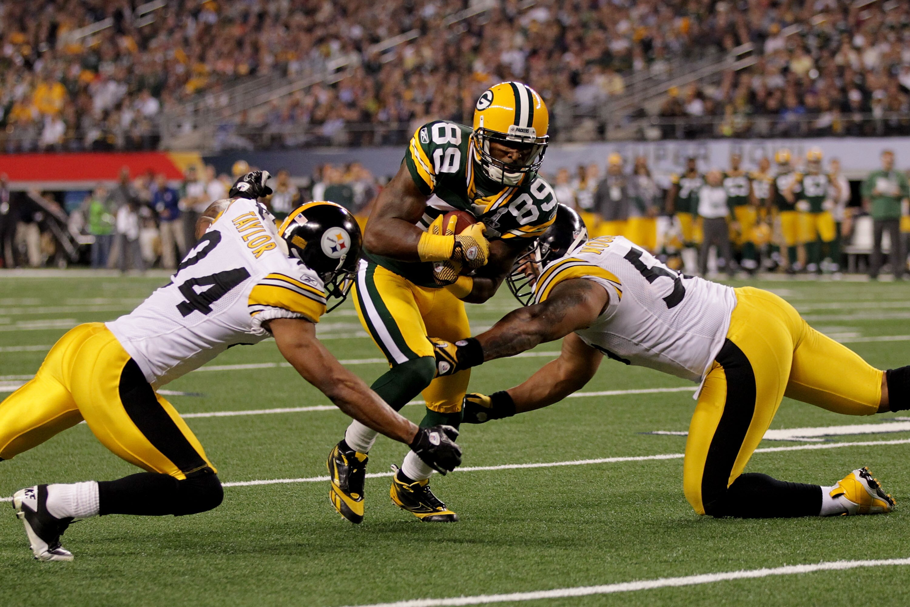 ARLINGTON, TX - FEBRUARY 06:  James Jones #89 of the Green Bay Packers tries to avoid the tackle of LaMarr Woodley #56 and Ike Taylor #24 of the Pittsburgh Steelers and during Super Bowl XLV at Cowboys Stadium on February 6, 2011 in Arlington, Texas.  (Ph
