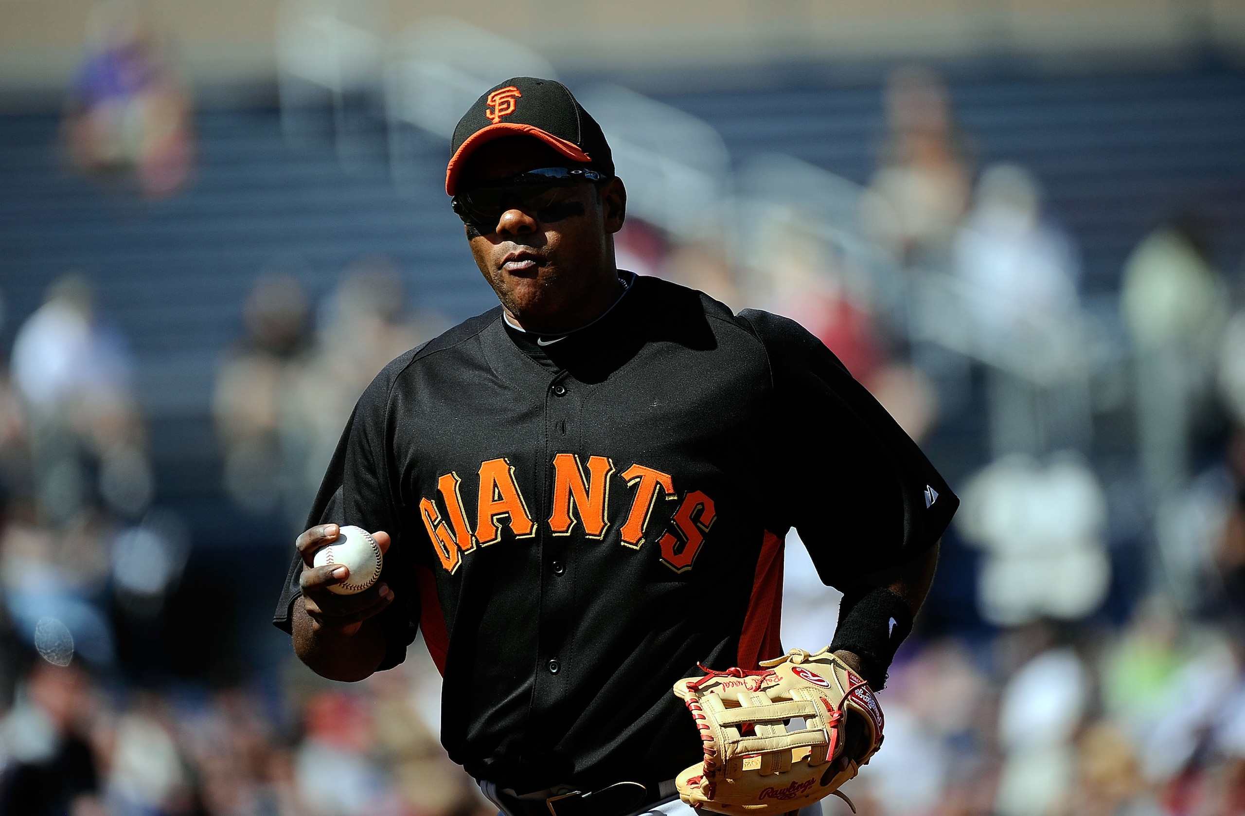 PEORIA, AZ - MARCH 08:  Miguel Tejada #10 of the San Francisco Giants holds the baseball as he runs to the dugout against Seattle Mariners during the spring training baseball game against at Peoria Stadium on March 8, 2011 in Peoria, Arizona.  (Photo by K