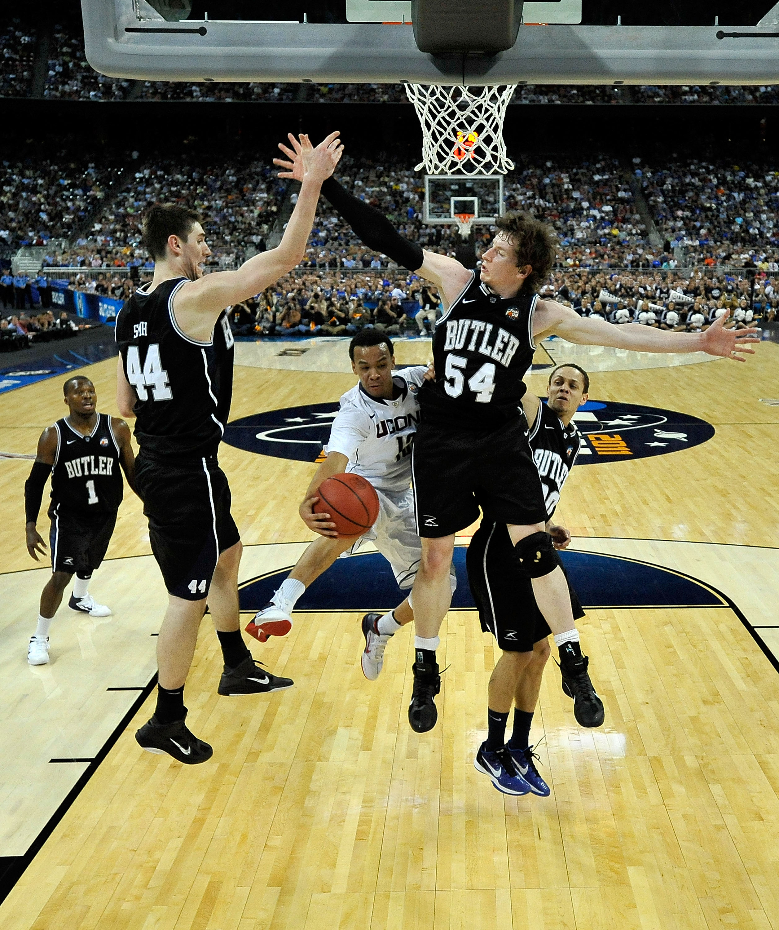 HOUSTON, TX - APRIL 04:  Shabazz Napier #13 of the Connecticut Huskies passes the ball against Andrew Smith #44 and Matt Howard #54 of the Butler Bulldogs during the National Championship Game of the 2011 NCAA Division I Men's Basketball Tournament at Rel