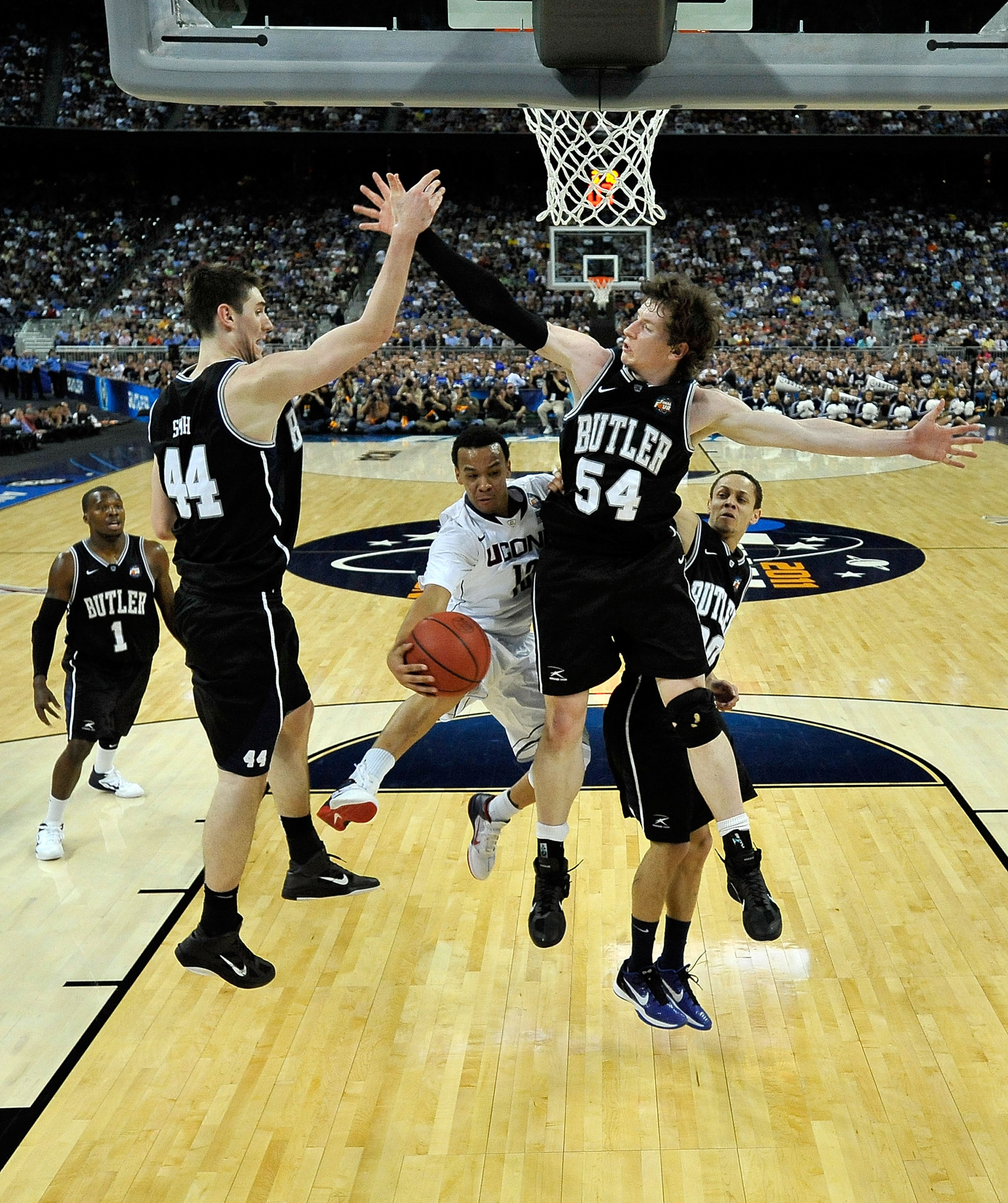 HOUSTON, TX - APRIL 04:  Shabazz Napier #13 of the Connecticut Huskies passes the ball against Andrew Smith #44 and Matt Howard #54 of the Butler Bulldogs during the National Championship Game of the 2011 NCAA Division I Men's Basketball Tournament at Rel