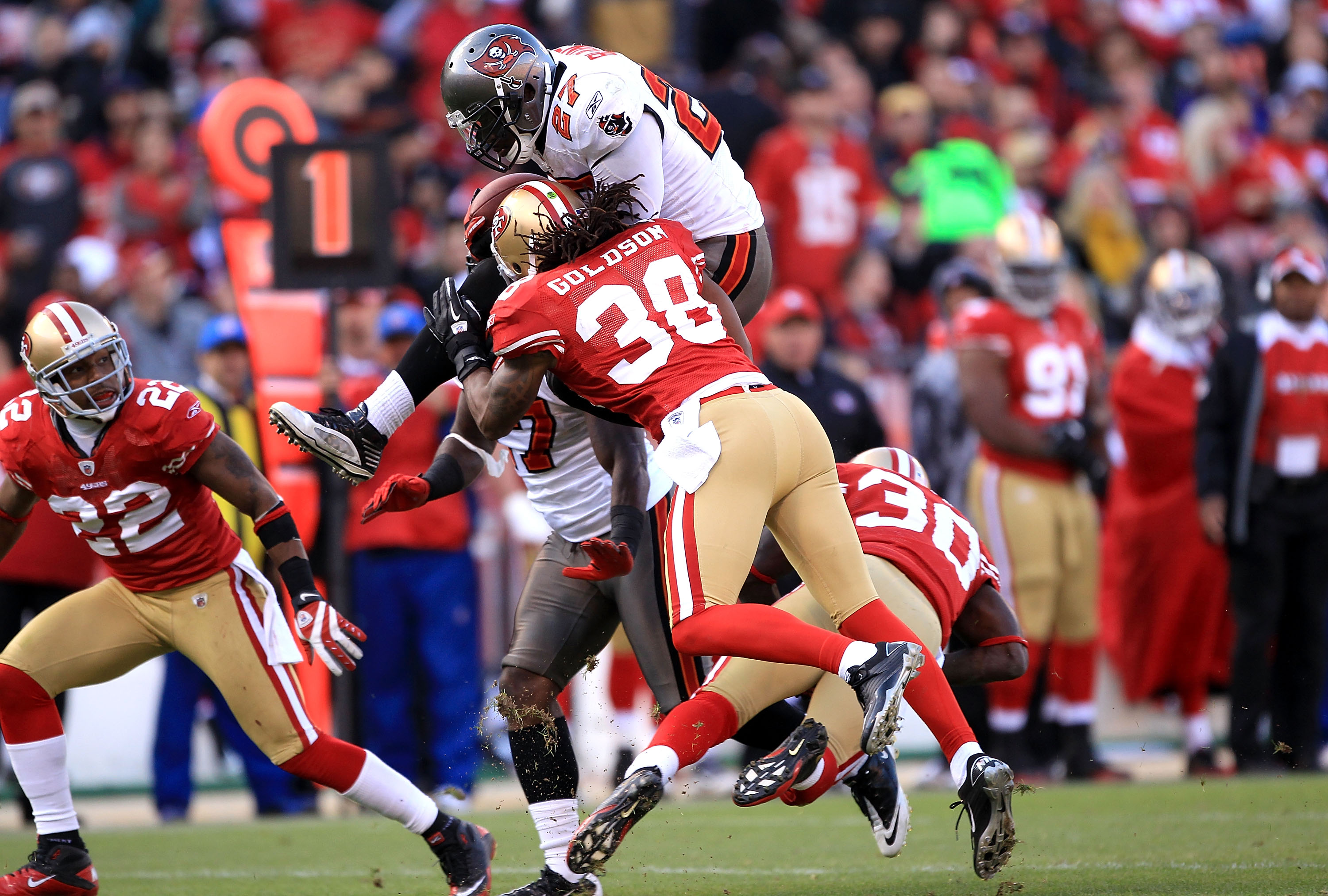 SAN FRANCISCO - NOVEMBER 21:  LeGarrette Blount #27 of the Tampa Bay Buccaneers leaps over Reggie Smith #30 when he is hit by Dashon Goldson #38 of the San Francisco 49ers at Candlestick Park on November 21, 2010 in San Francisco, California.  (Photo by E