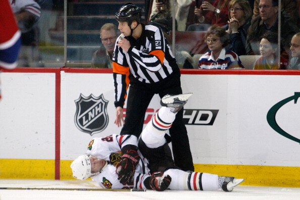 MONTREAL, CANADA - APRIL 5:  NHL referee Eric Furlatt #27 stops play for the injured Troy Brouwer #22 of the Chicago Blackhawks during the NHL game against the Montreal Canadiens at the Bell Centre on April 5, 2011 in Montreal, Quebec, Canada.  The Canadi