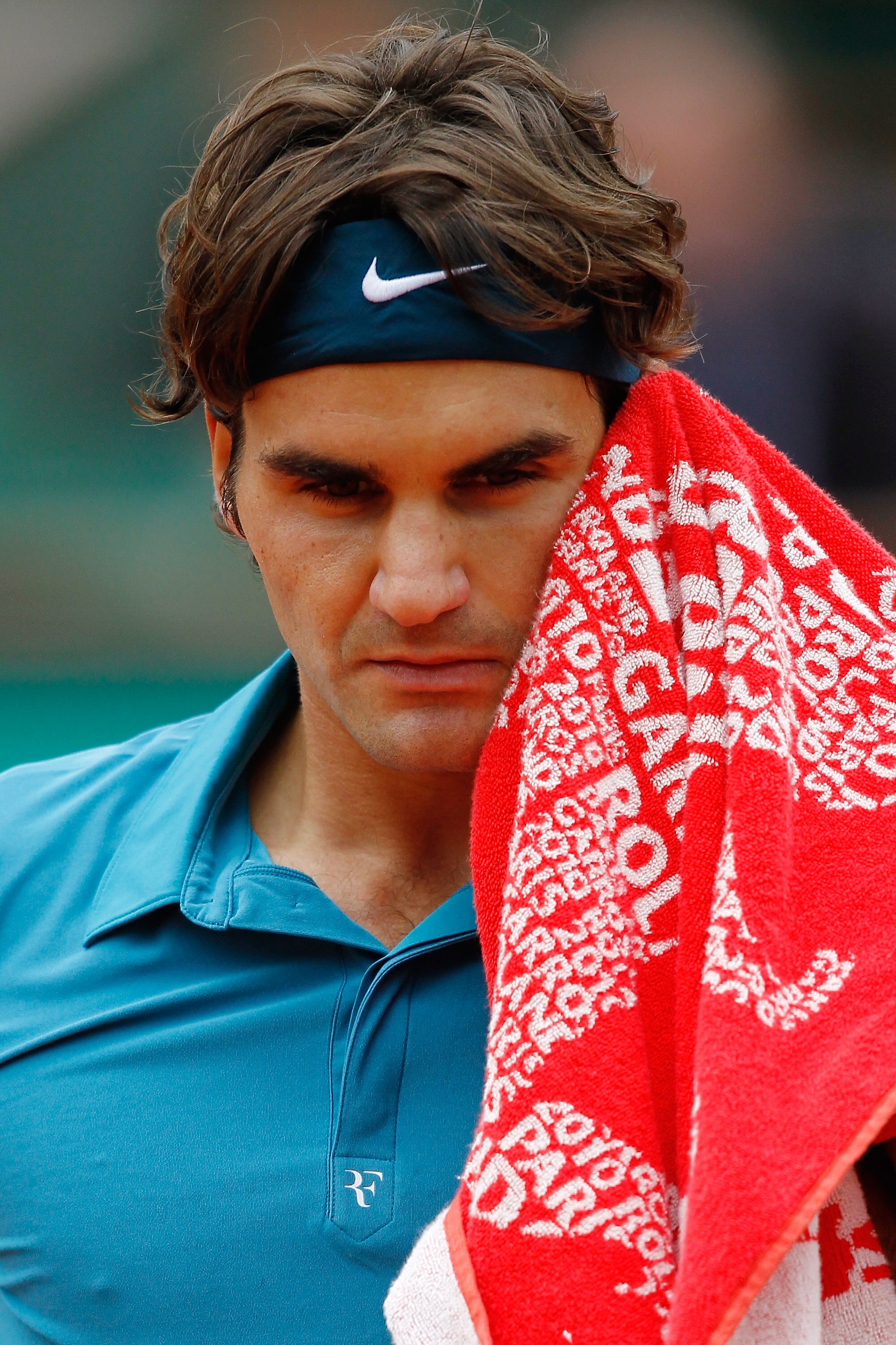 PARIS - JUNE 01:  Roger Federer of Switzerland wipes his face during the men's singles quarter final match between Robin Soderling of Sweden and Roger Federer of Switzerland at the French Open on day ten of the French Open at Roland Garros on June 1, 2010