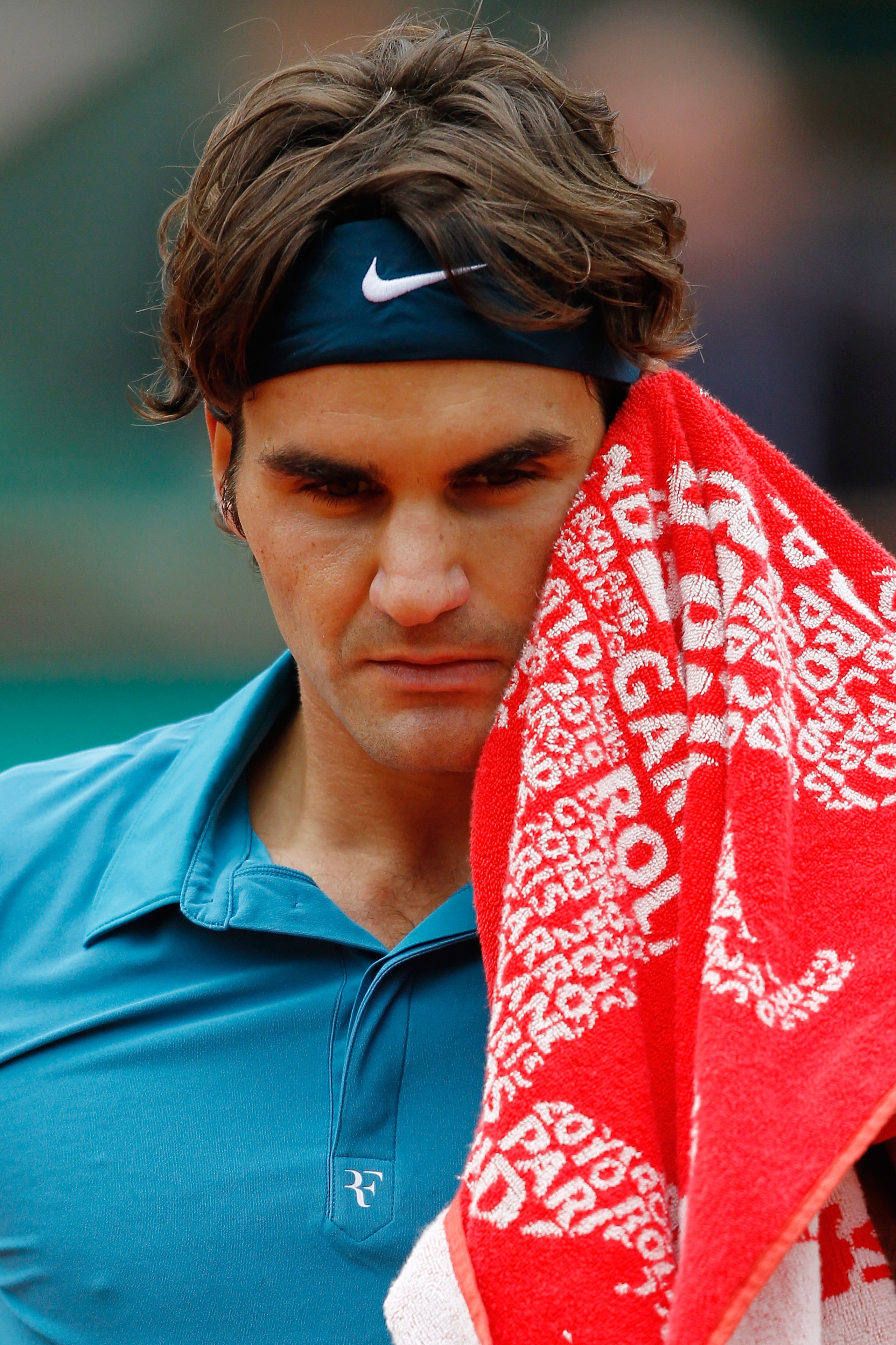 PARIS - JUNE 01:  Roger Federer of Switzerland wipes his face during the men's singles quarter final match between Robin Soderling of Sweden and Roger Federer of Switzerland at the French Open on day ten of the French Open at Roland Garros on June 1, 2010