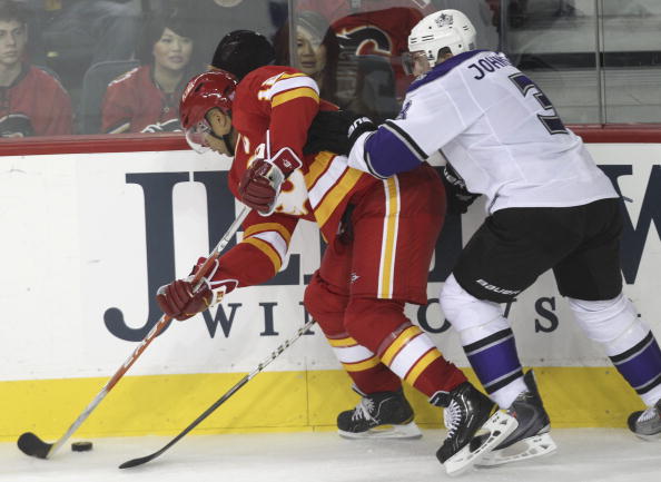 CALGARY, AB - OCTOBER 10:  Jarome Iginla #12  of the Calgary Flames keeps keeps the puck away from Jack Johnson  #3 of the Los Angeles Kings in third period NHL action on October 10, 2010 at the Scotiabank Saddledome in Calgary, Alberta, Canada. (Photo by