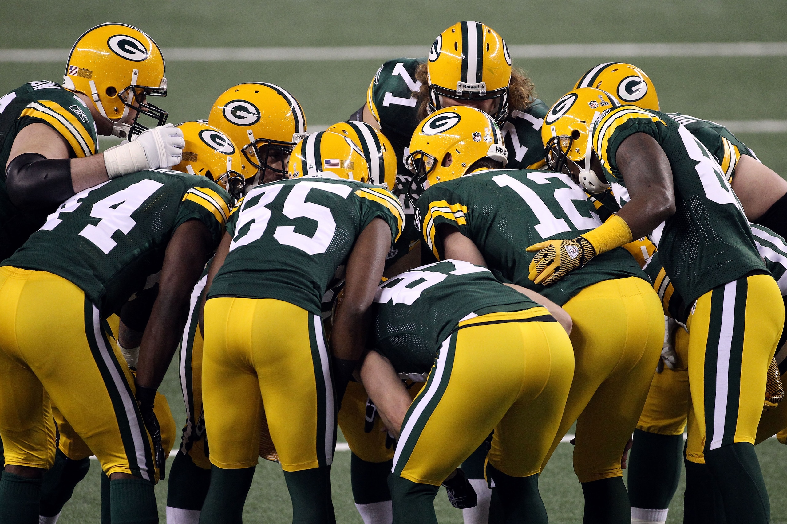 ARLINGTON, TX - FEBRUARY 06: Aaron Rodgers #12 of the Green Bay Packers huddles with teammates during Super Bowl XLV at Cowboys Stadium on February 6, 2011 in Arlington, Texas.  (Photo by Streeter Lecka/Getty Images)