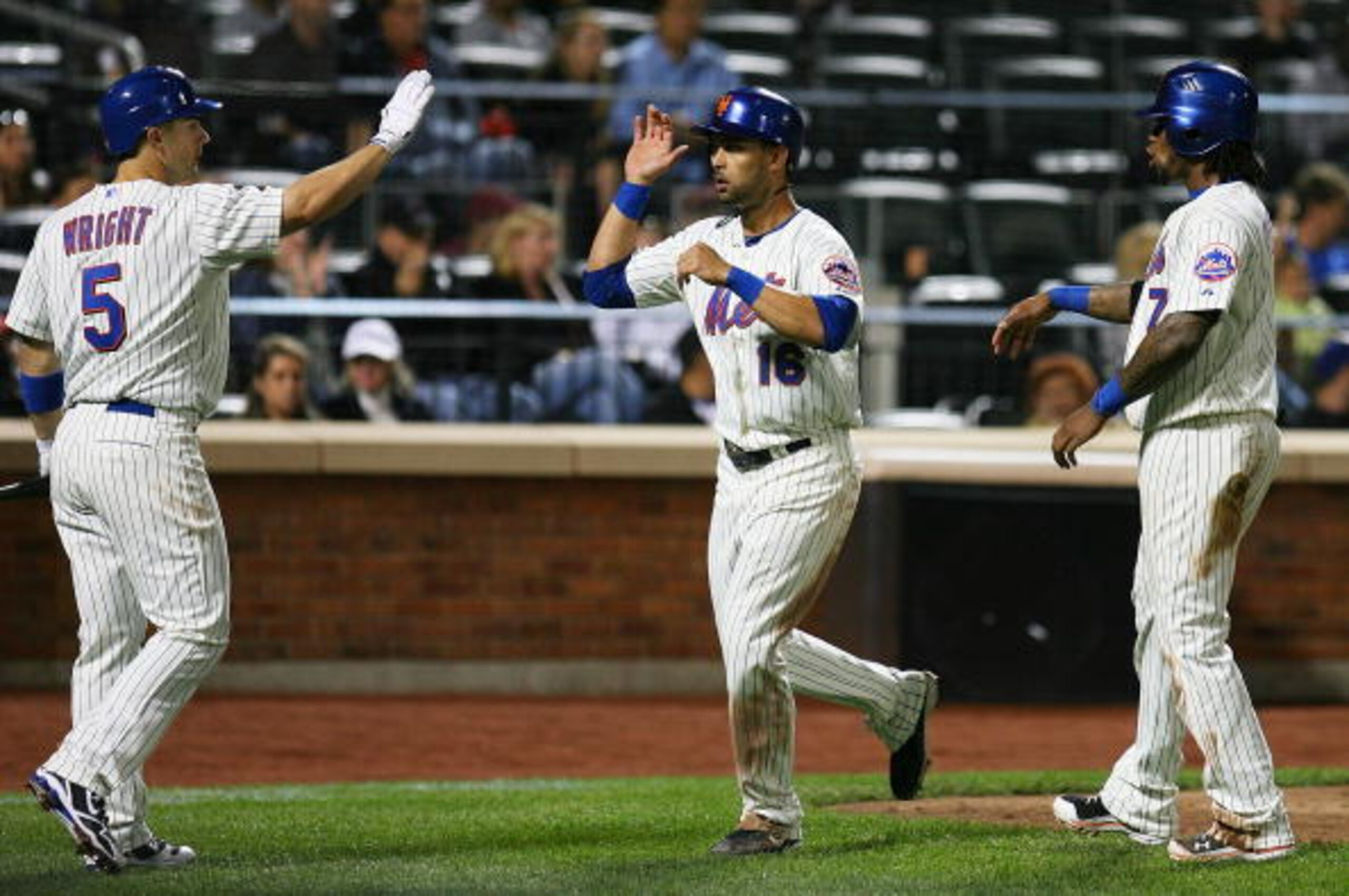 NEW YORK - SEPTEMBER 14: Angel Pagan #16 of the New York Mets is welcomed home by teammates David Wright #5 and Jose Reyes #7 after running in a two-run double hit by Carlos Beltran #15 (not seen) of the Mets in the fourth inning against the Pittsburgh Pi