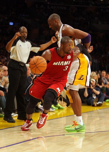LOS ANGELES, CA - DECEMBER 25: Dwyane Wade #3 of the Miami Heat dribbles the ball to the basket as Kobe Bryant #24 of the Los Angeles Lakers gets called for a blocking foul during the NBA game at Staples Center on December 25, 2010 in Los Angeles, Califor