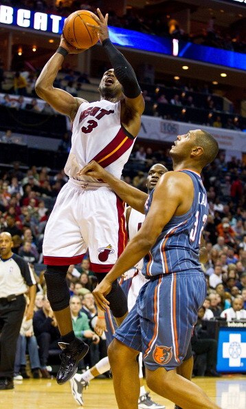 CHARLOTTE, NC - FEBRUARY 04:  Dwyane Wade #3 of the Miami Heat is fouled by Boris Diaw #32 of the Charlotte Bobcats at the Time Warner Cable Arena on February 4, 2011 in Charlotte, North Carolina.  The Heat defeated the Bobcats 109-97.  NOTE TO USER: User