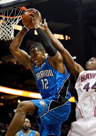 Dwight Howard tearing a rebound away from his opponent.