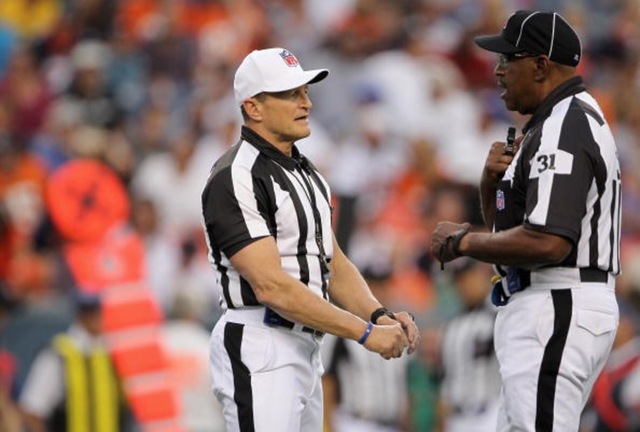 DENVER - AUGUST 21: (L-R) Referee Ed Hochuli talks with umpire Chad Brown as they oversee the action between the Denver Broncos and the Detroit Lions during preseason NFL action at INVESCO Field at Mile High on August 21, 2010 in Denver, Colorado. The Li DENVER - AUGUST 21: (L-R) Referee Ed Hochuli talks with umpire Chad Brown as they oversee the action between the Denver Broncos and the Detroit Lions during preseason NFL action at INVESCO Field at Mile High on August 21, 2010 in Denver, Colorado. The Li