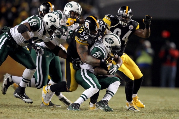 PITTSBURGH, PA - JANUARY 23:  LaMarr Woodley #56 of the Pittsburgh Steelers tackles LaDainian Tomlinson #21 of the New York Jets during the 2011 AFC Championship game at Heinz Field on January 23, 2011 in Pittsburgh, Pennsylvania. The Steelers won 24-19.