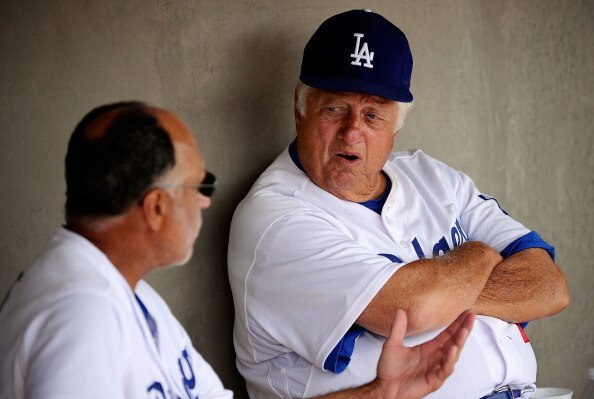 GLENDALE, AZ - MARCH 15:  Hall of Fame manager Tommy Lasorda #2 of the Los Angeles Dodgers speaks to first base coach Davey Lopes in the dugout prior to the start of the spring training baseball game against the Texas Rangers at Camelback Ranch on March 1