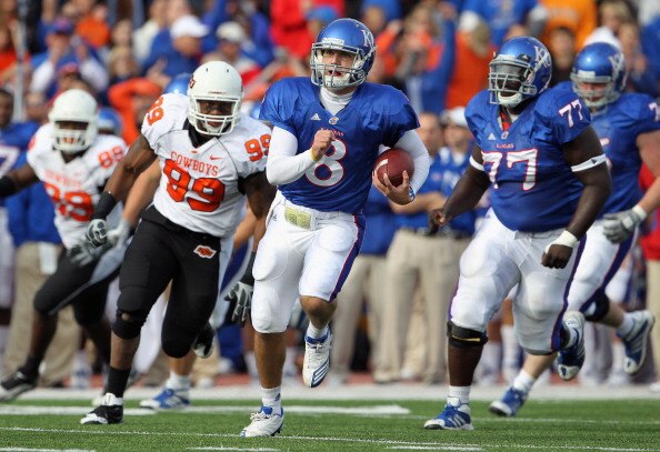 LAWRENCE, KS - NOVEMBER 20:   Quarterback Quinn Mecham #8 of the Kansas Jayhawks scrambles during the game against the Oklahoma State Cowboys on November 20, 2010 at Memorial Stadium in Lawrence, Kansas.  (Photo by Jamie Squire/Getty Images)