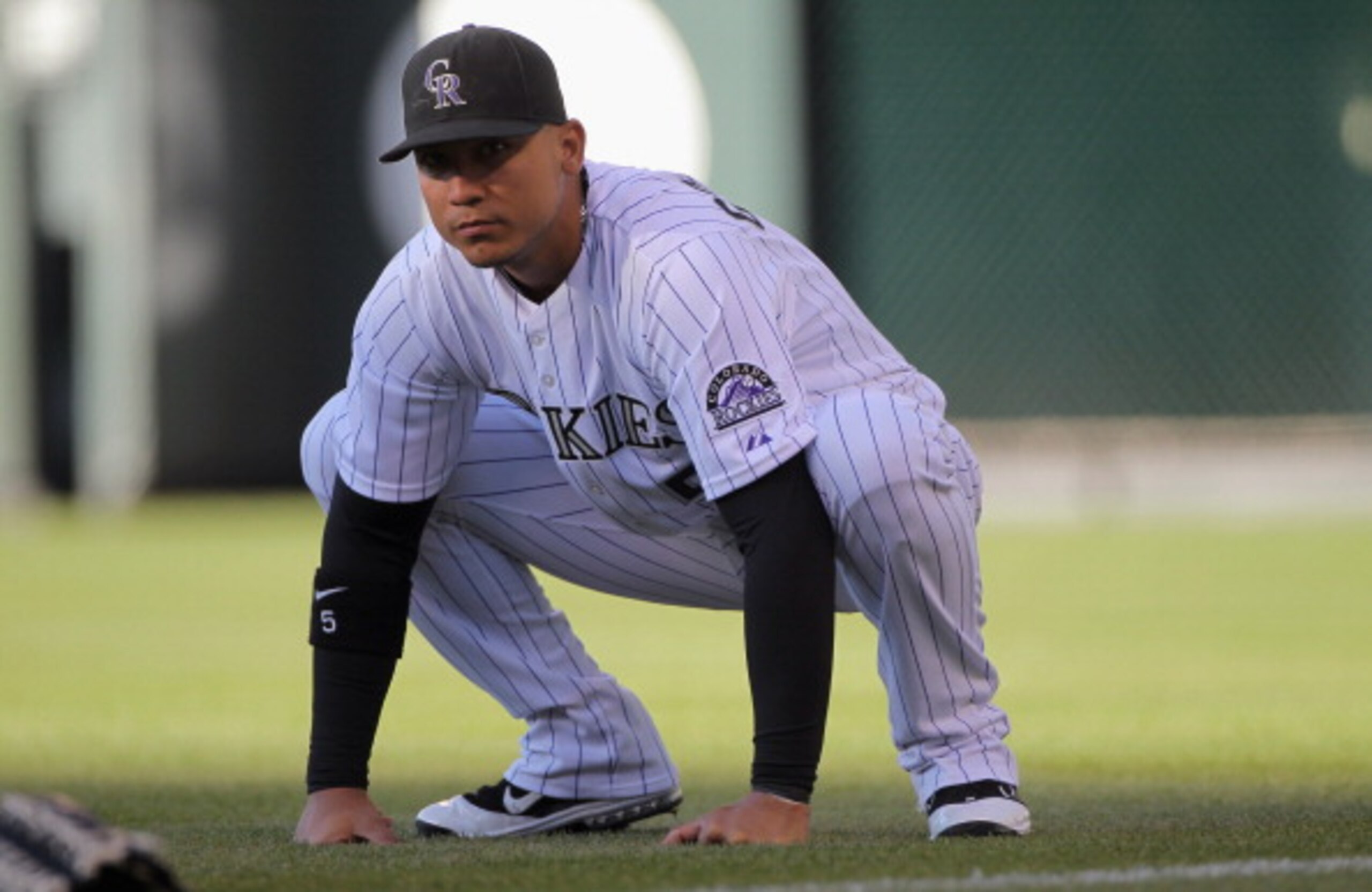 DENVER, CO - APRIL 02:  Carlos Gonzalez #5 of the Colorado Rockies stretches prior to facing the Arizona Diamondbacks at Coors Field on April 2, 2011 in Denver, Colorado.  (Photo by Doug Pensinger/Getty Images)