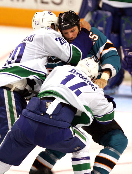 SAN JOSE, CA - SEPTEMBER 18:  Dave Scatchard #20 and Alexandre Burrows #14 of the Vancouver Canucks and Jody Shelley #45 of the San Jose Sharks get in a fight during their preseason game at HP Pavilion on September 18, 2009 in San Jose, California.  (Phot